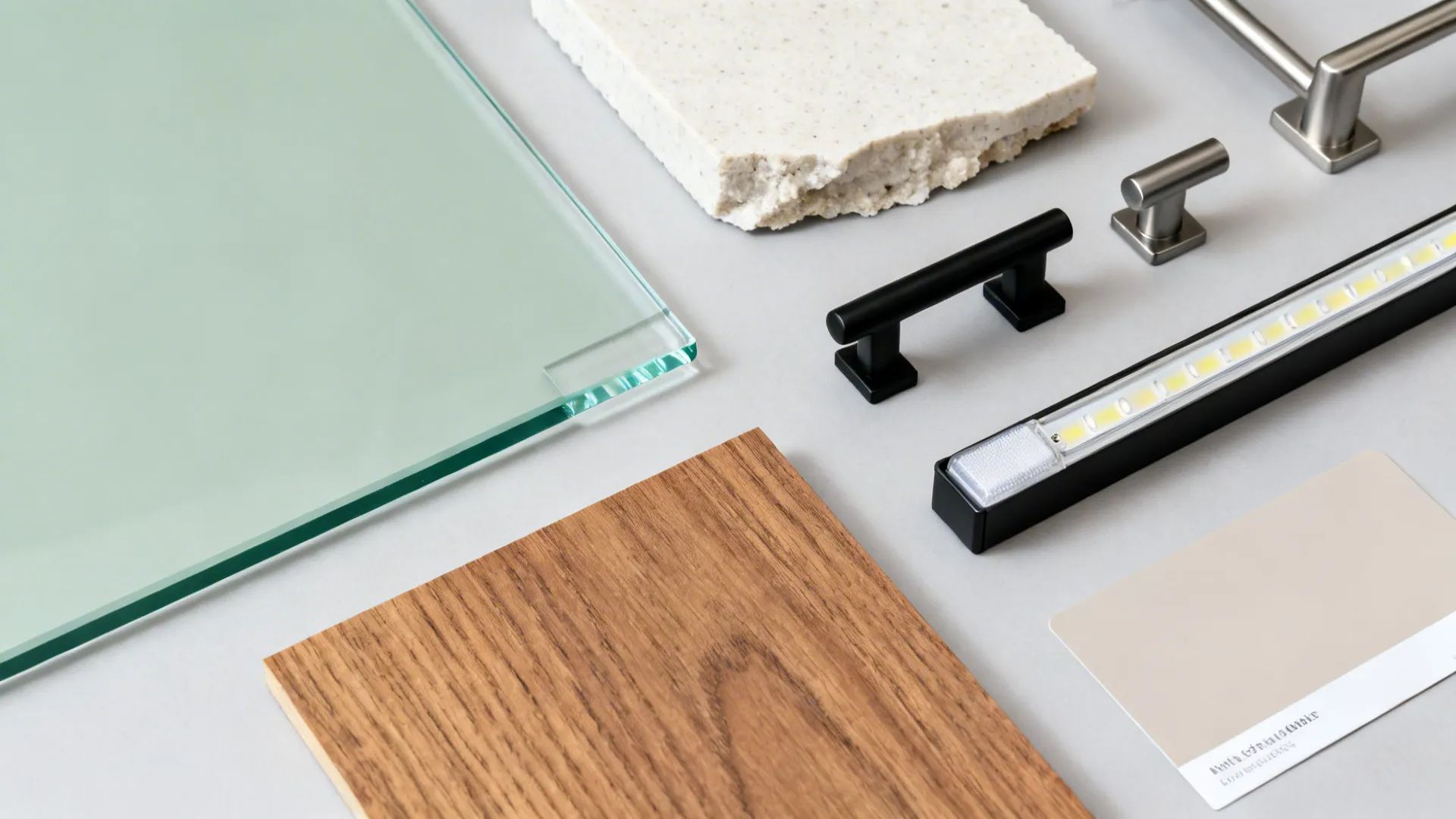 Flat lay with sage glass, quartz, teak laminate, matte hardware, and LED diffuser