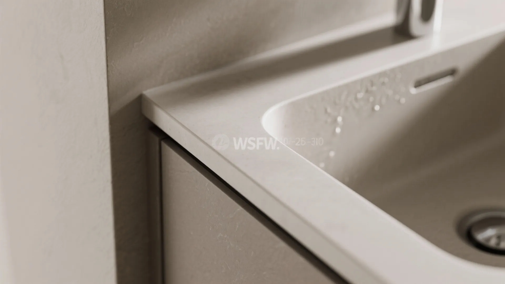 Close up view of a modern stone kitchen sink with water drops and grey cabinet