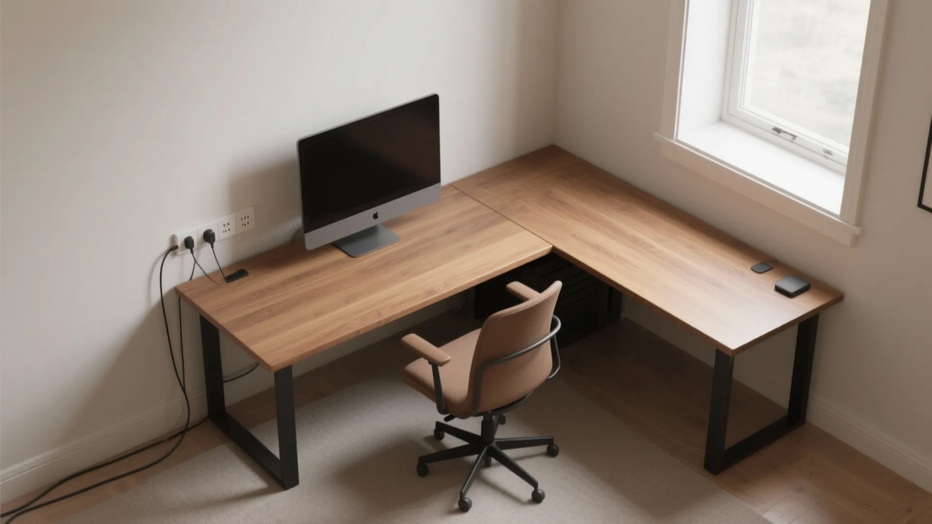 Modern home office with wooden corner desk computer screen brown chair and natural window light
