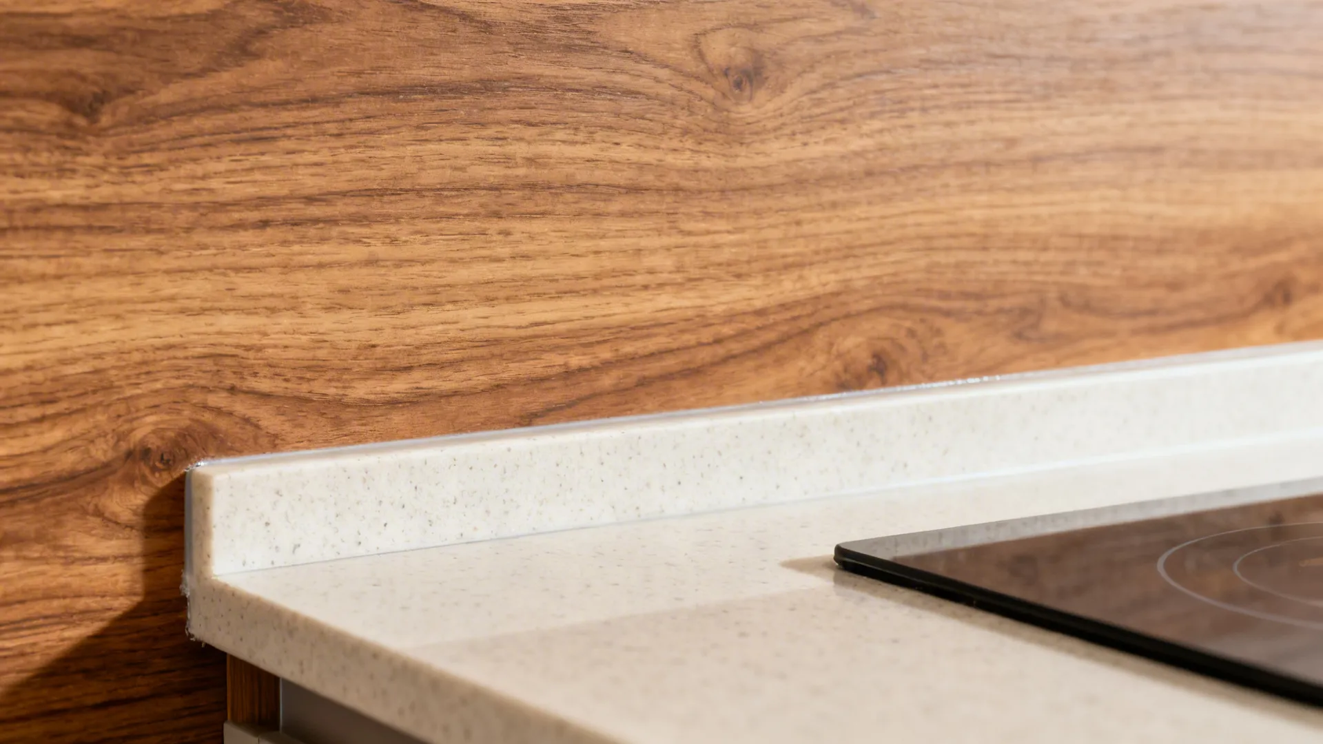 Macro of oak-look laminate grain and light quartz lip showing texture and sealed edges.
