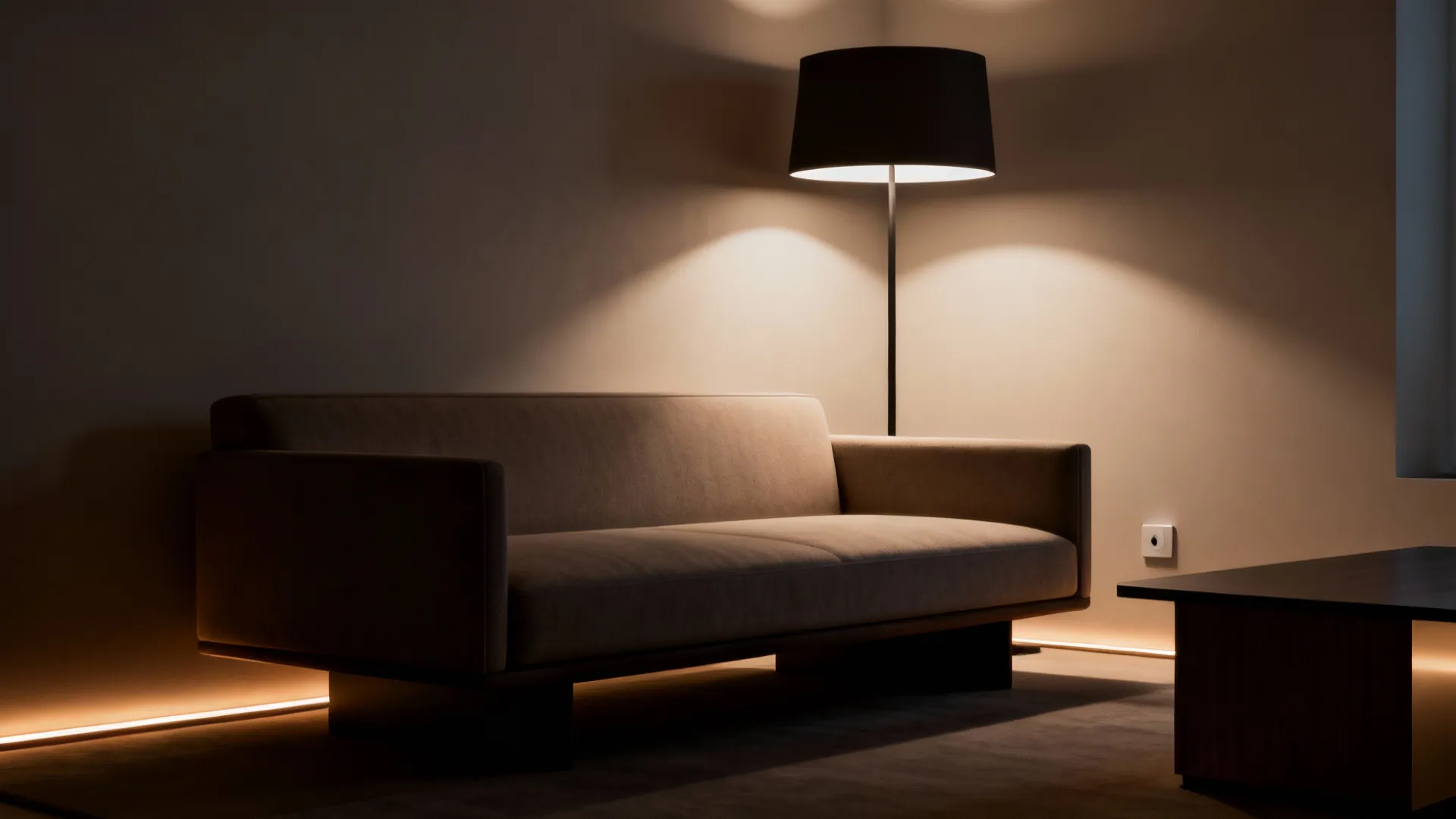 Floor lamp behind a low-back sofa creating subtle backlighting and silhouette definition