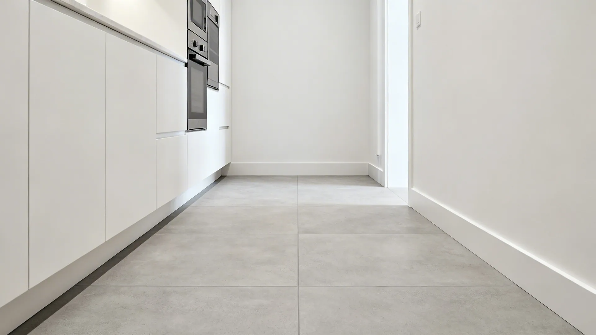 Galley kitchen with 24x24 light gray porcelain tiles and minimal grout.