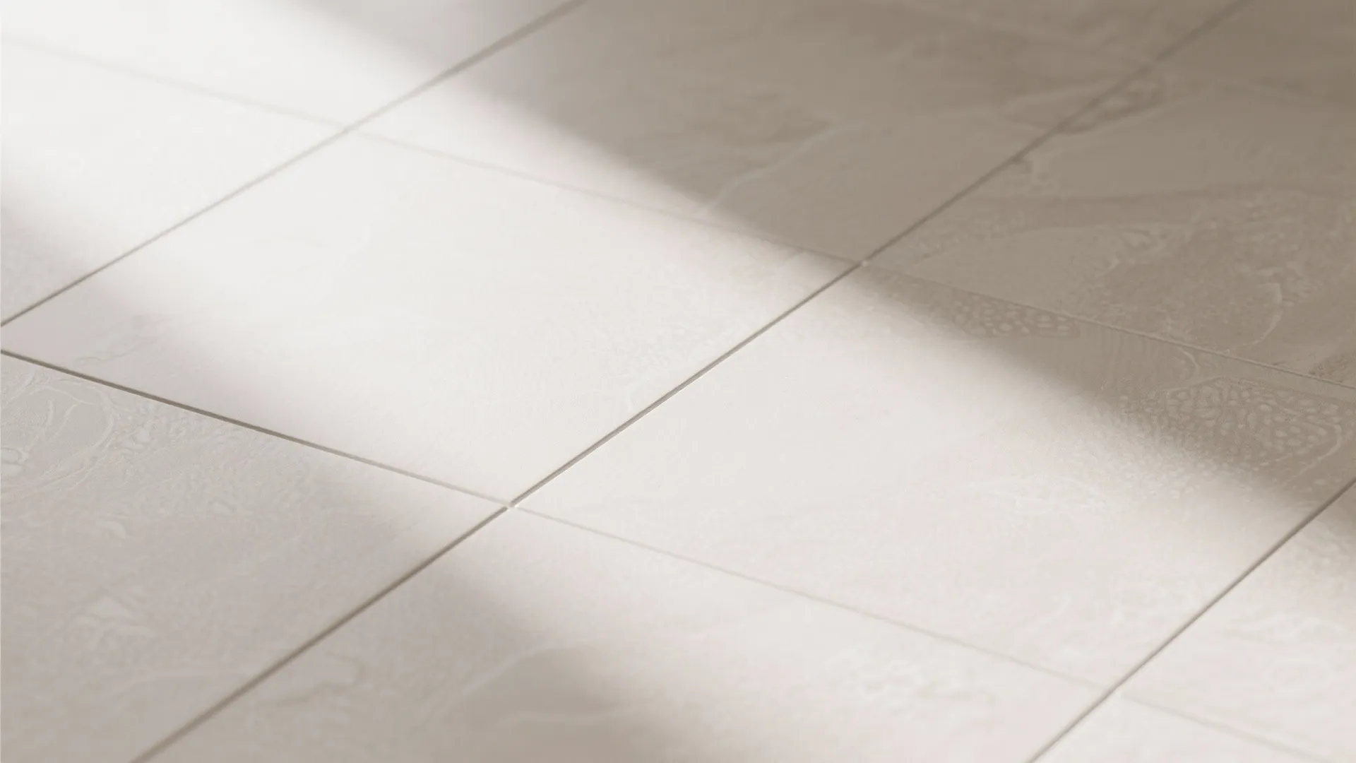 Close up of beige floor tiles with light patterns and shadow across the tile surface