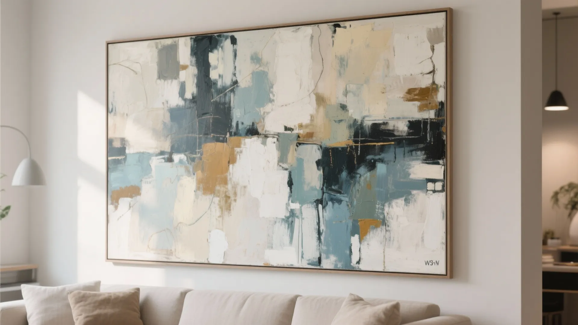 Large abstract painting with blue and tan colors hanging above a neutral sofa in living-room