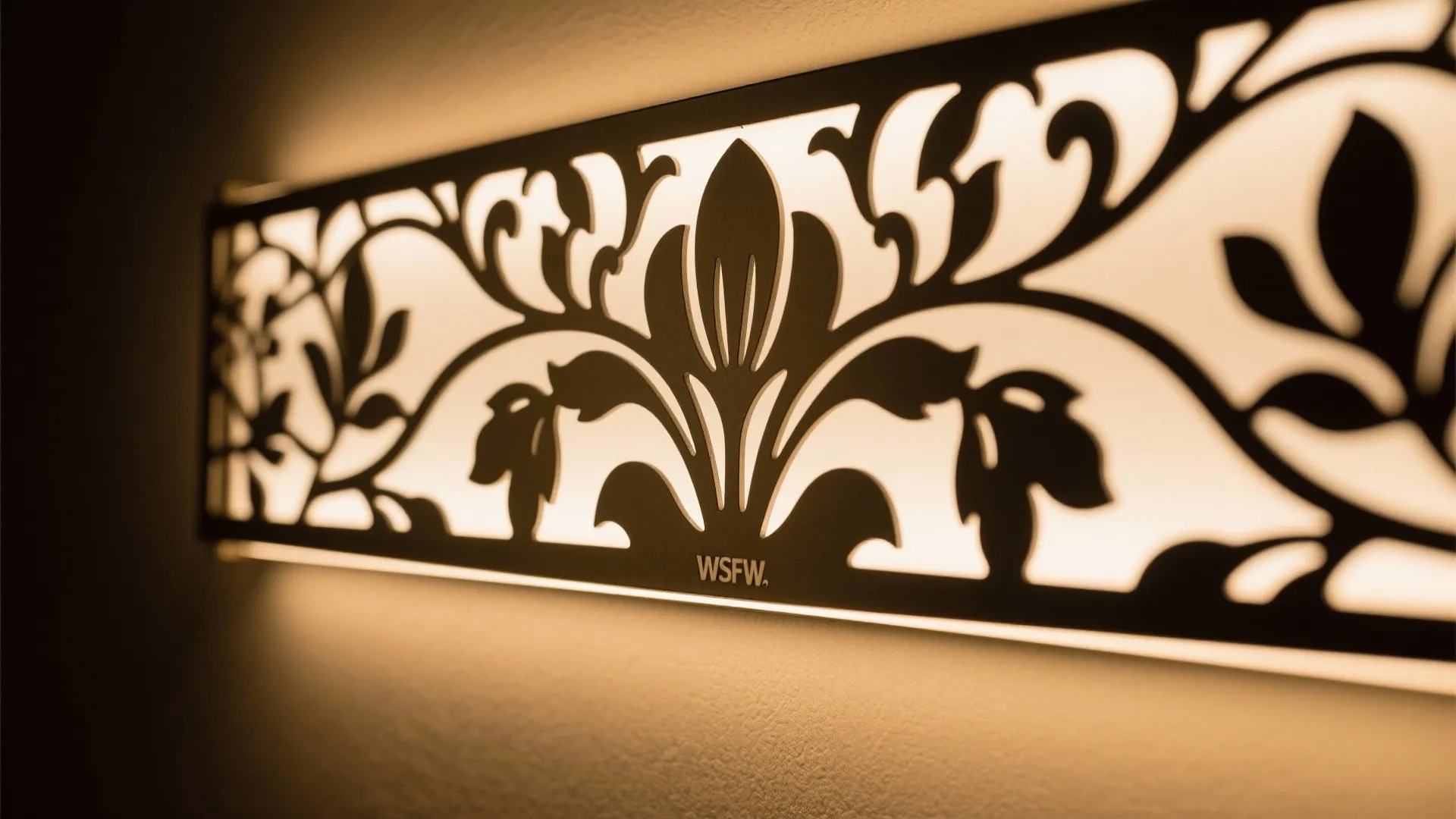 Modern black wall light with floral pattern silhouette and warm light glow on a wall
