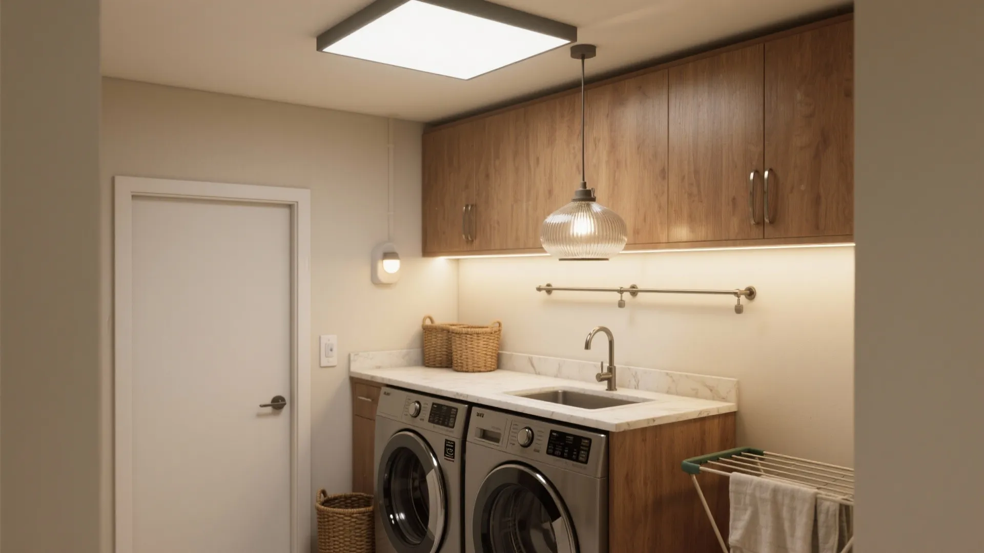 Modern laundry room featuring wooden cabinets with ceiling light and washer and dryer machine setup