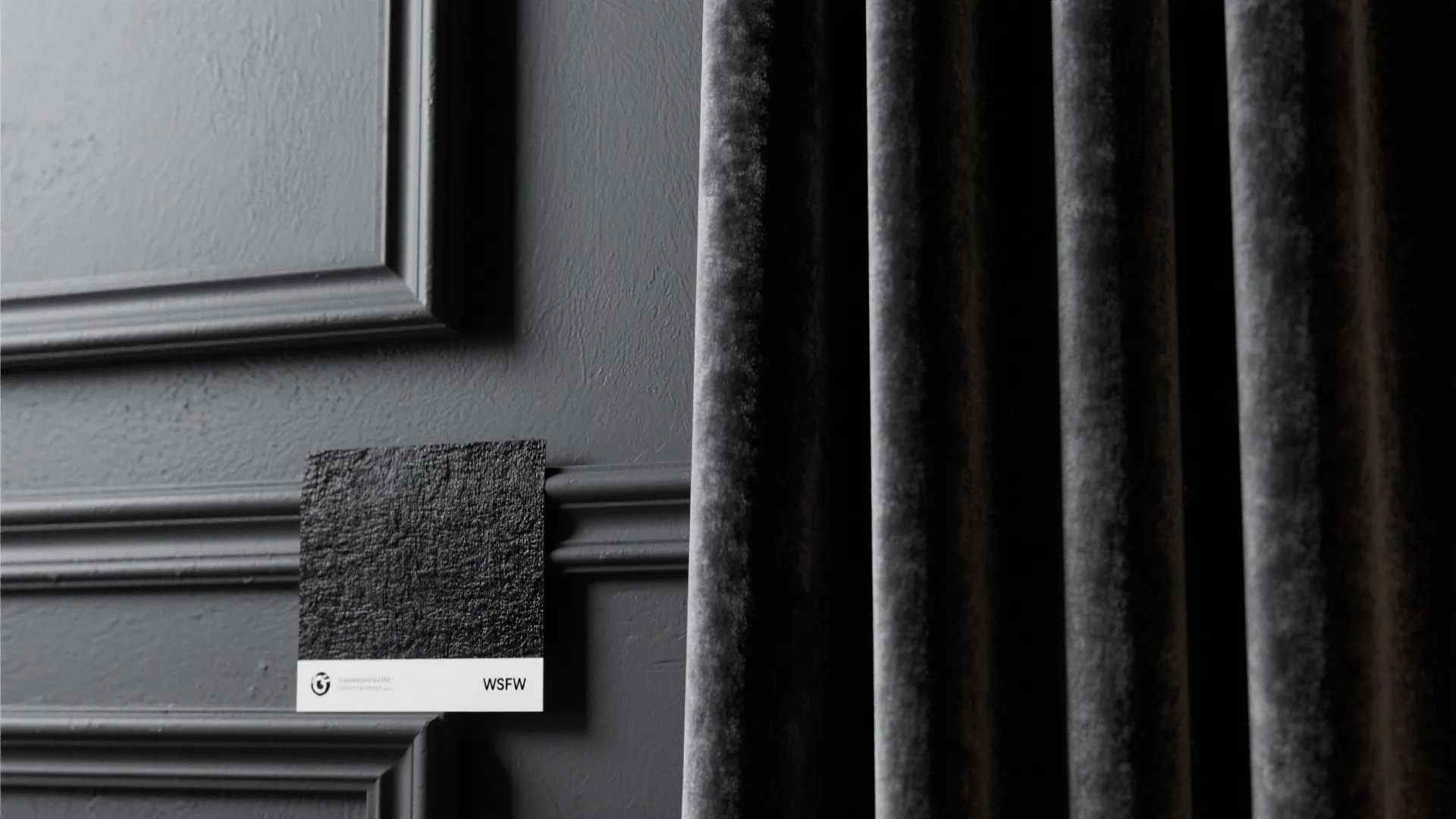 Close-up of layered black materials combining matte paint, satin trim and charcoal velvet