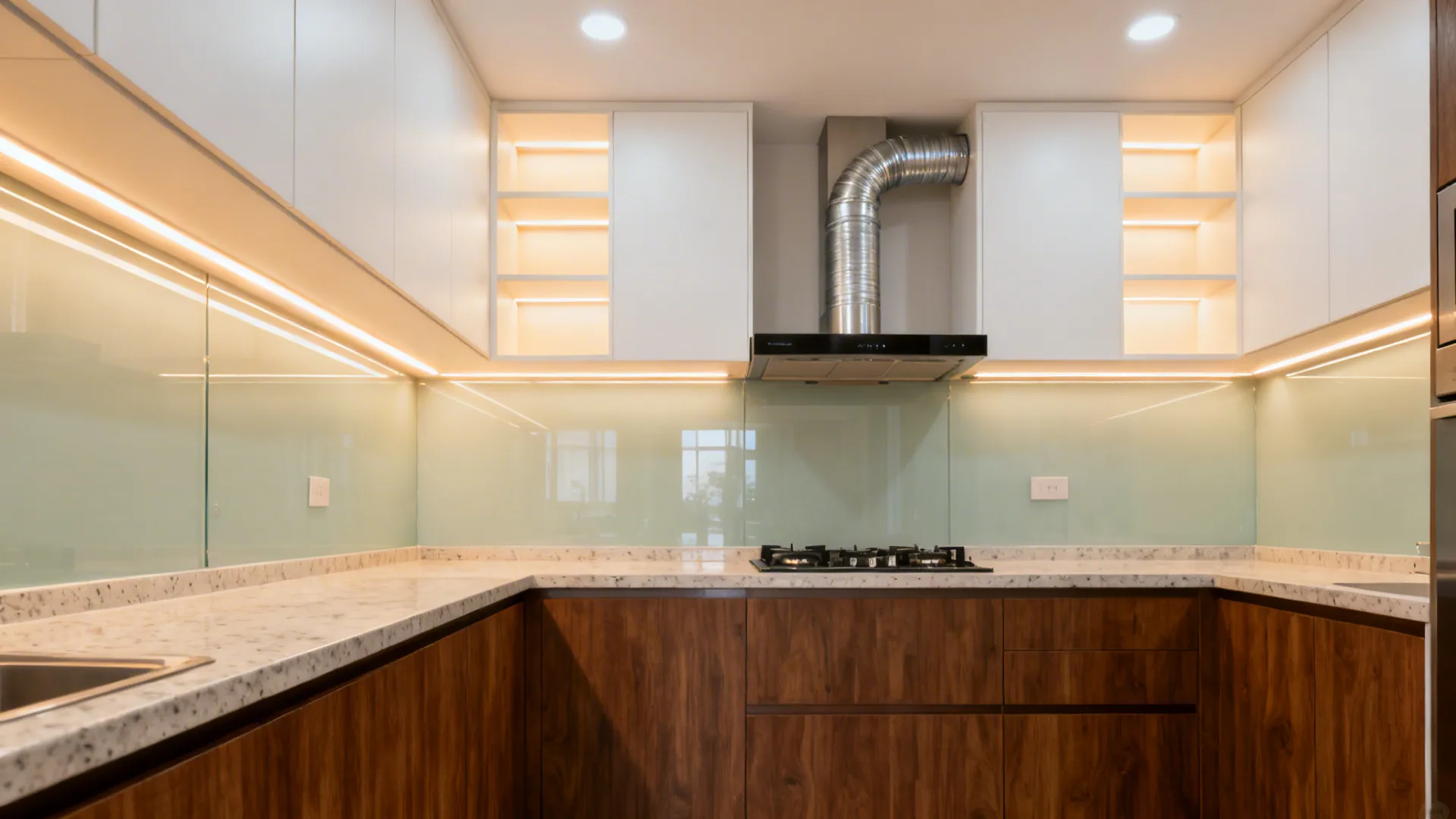 Layered kitchen lighting with warm LED strips and a sleek chimney over the hob.