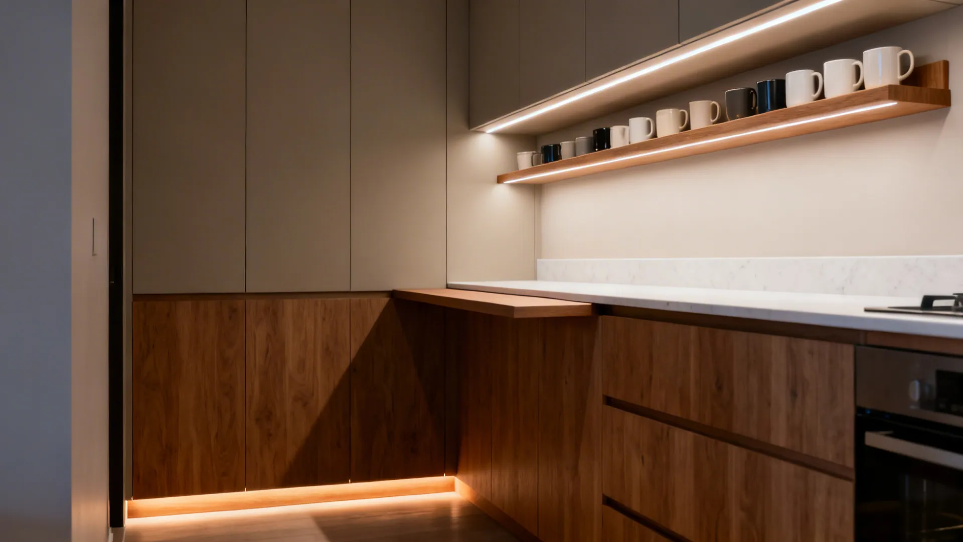 Parallel kitchen at dusk with task, ambient, and toe-kick lighting and a slim breakfast perch.