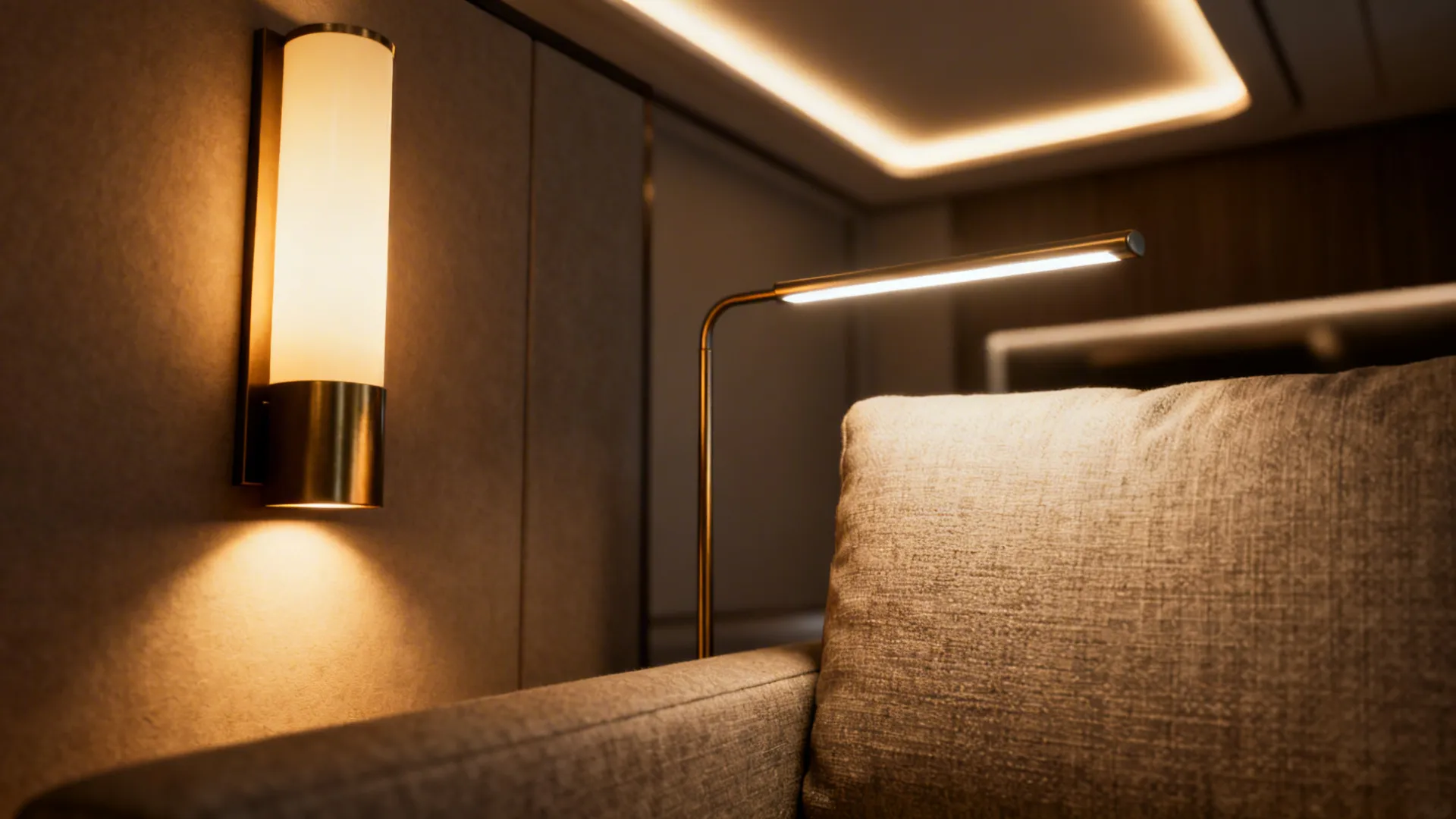Close-up of layered lighting: wall sconce, floor lamp, and ambient glow creating depth in a small living room