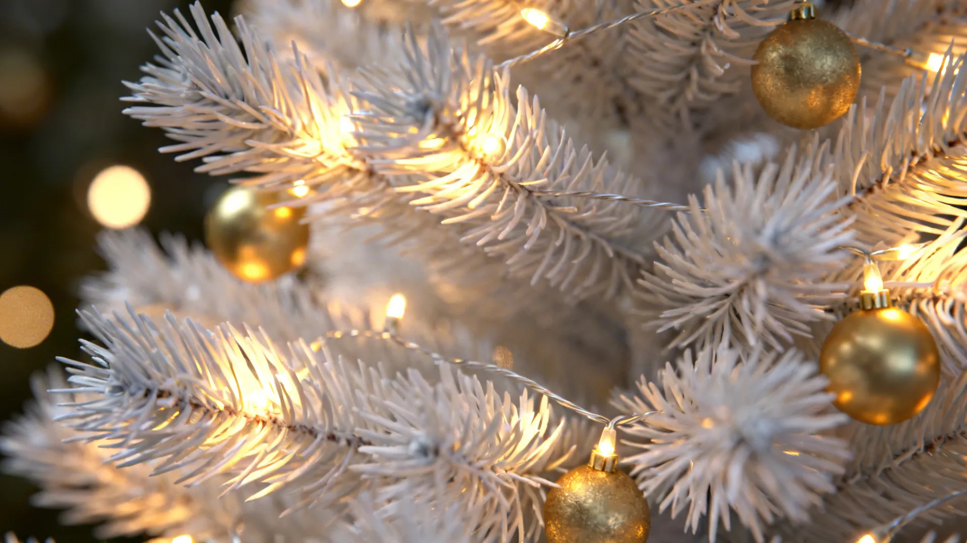 Close-up of warm LED lights on a white Christmas tree branch with pale gold ornament.