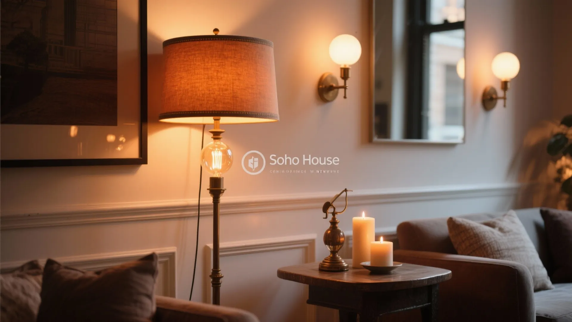 Living room featuring tall floor lamp round wall lights burning candles on table and sofa