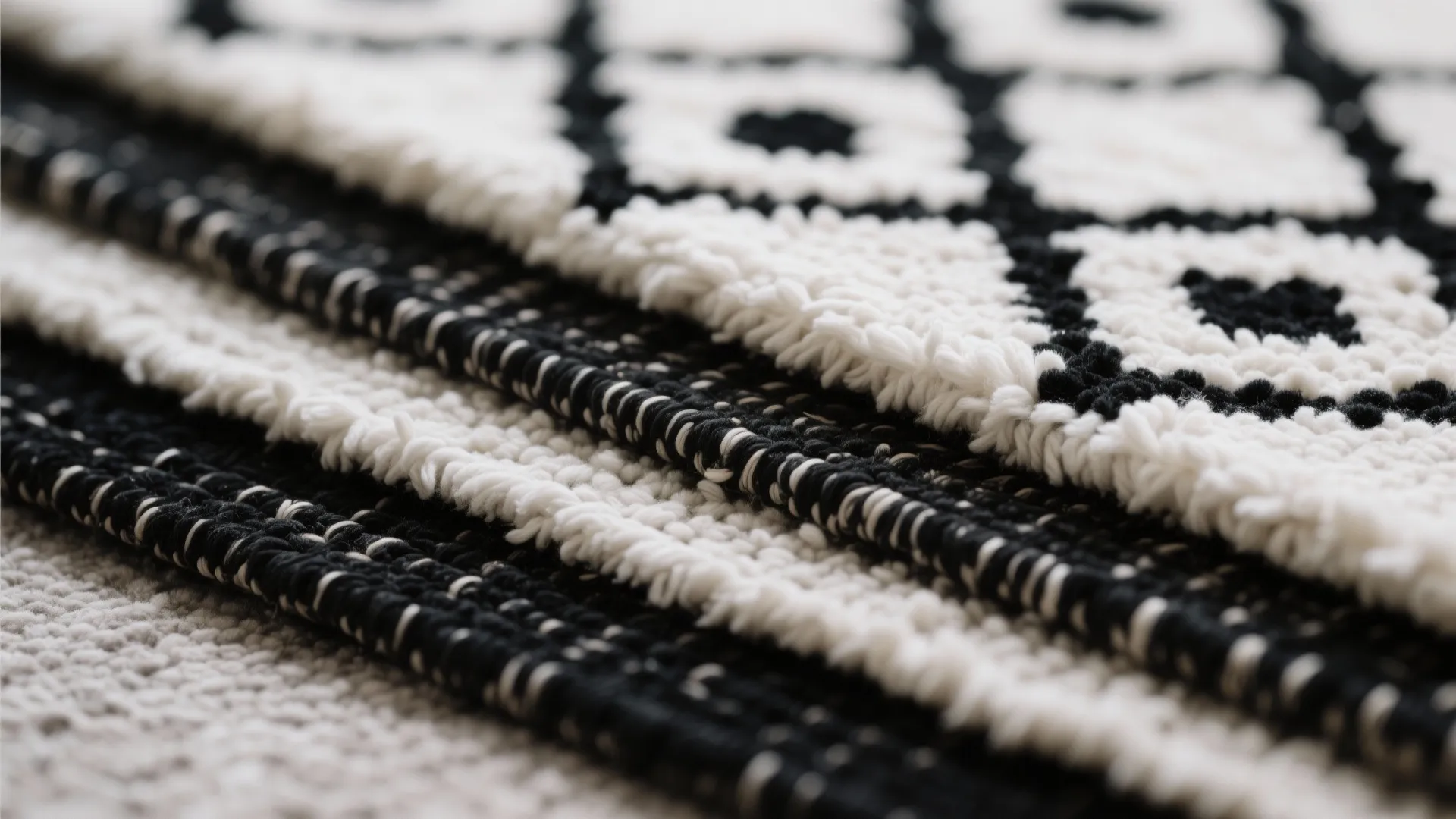 Close up of black and white floor rugs with soft textures and bold woven patterns