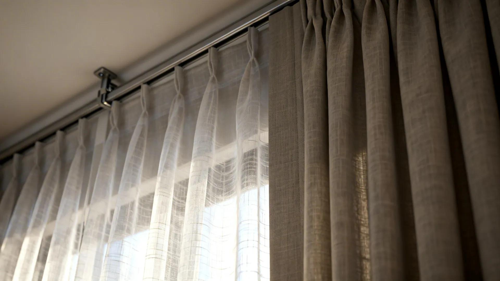 Close-up of translucent sheer layered over a slim blackout panel showing fabric texture and ceiling track.