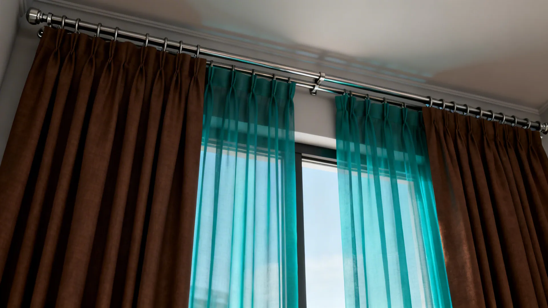 Layered teal sheers with outer brown blackout panels on double-rod hardware, showing light control.