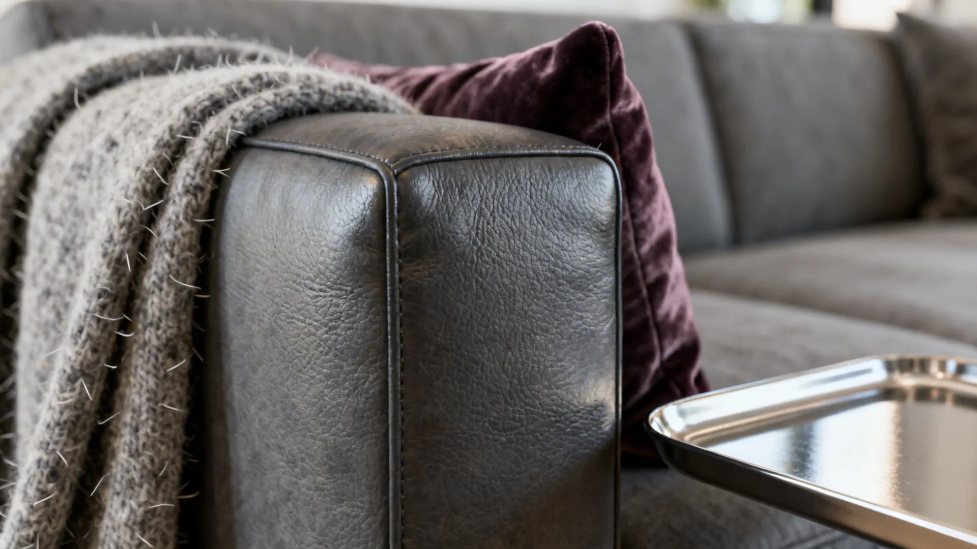 Macro detail of grey leather couch texture beside wool and velvet textiles
