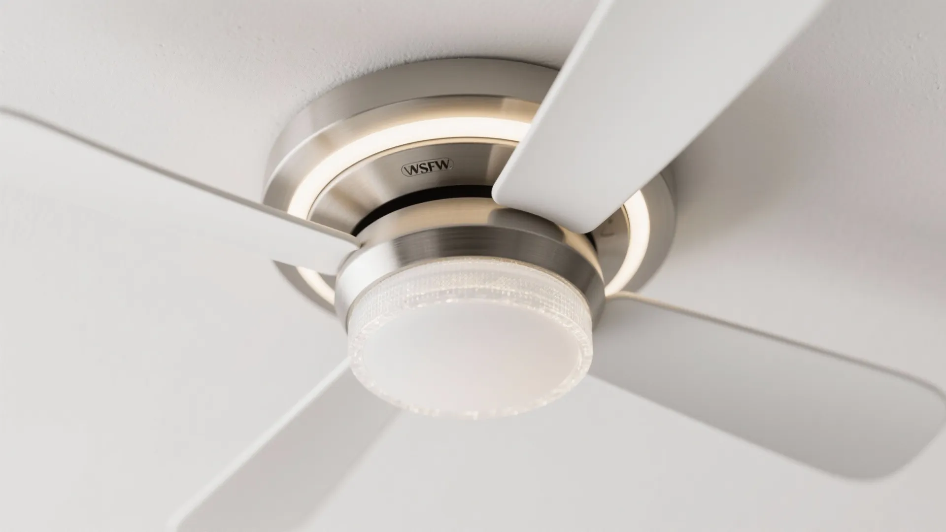Close-up of a flush-mount ceiling fan with a frosted LED ring and matte white blades.
