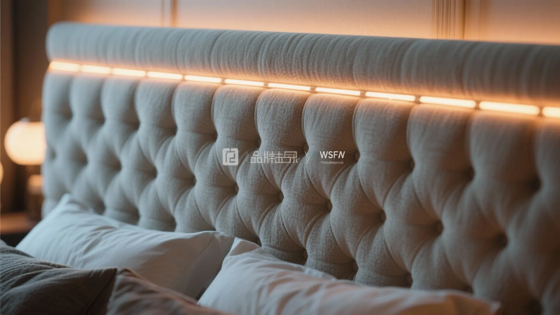 Grey tufted headboard with warm led light strip integrated into the design and white pillows
