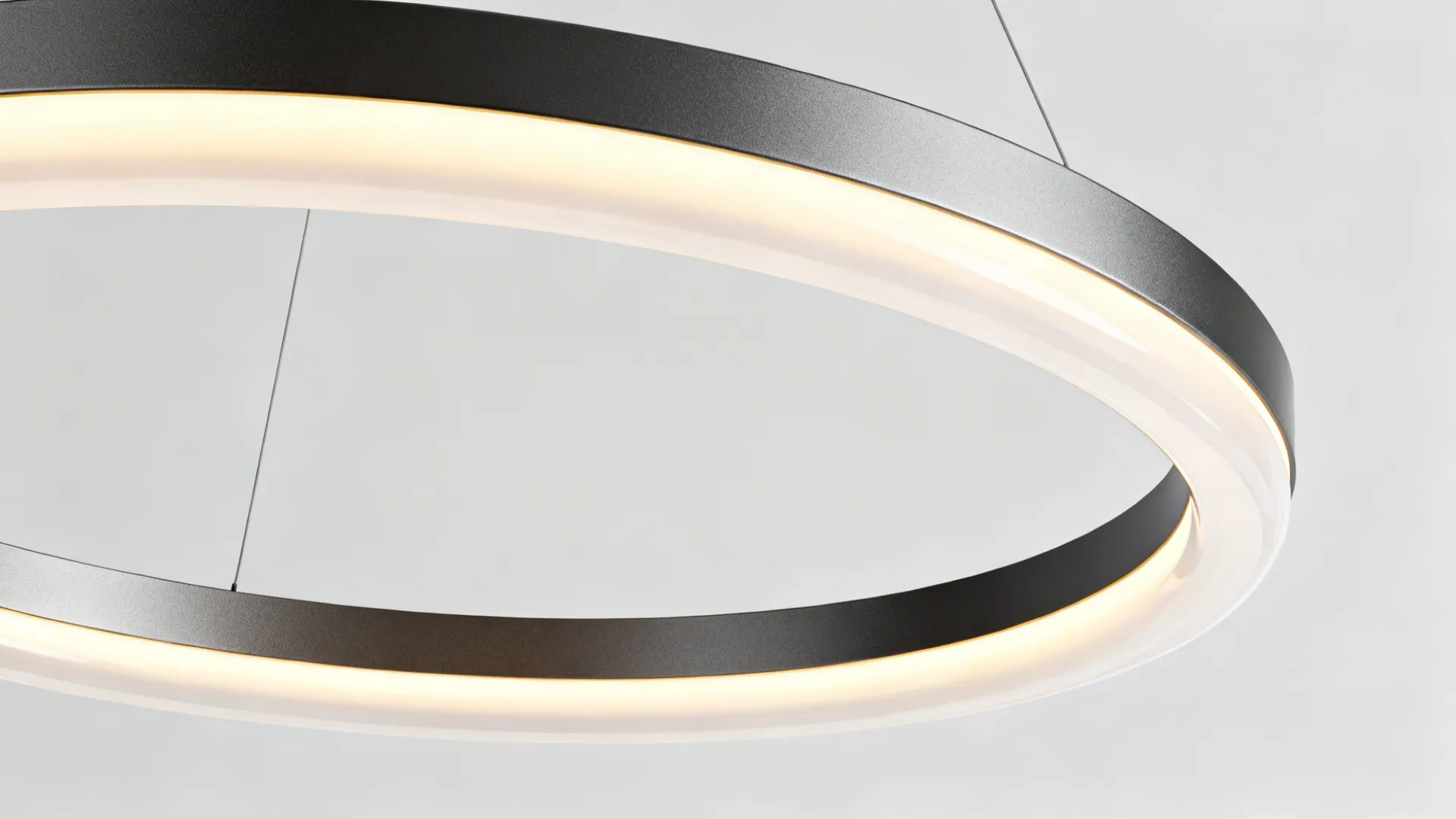 Close up view of a modern circular ring light fixture with grey metal and glowing