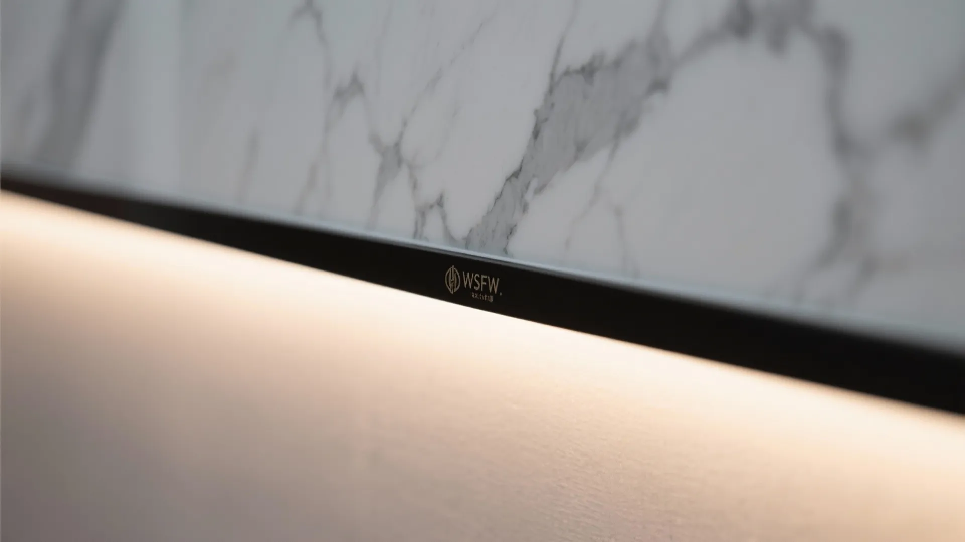 Macro of porcelain slab edge with warm LED backlight and matte black trim