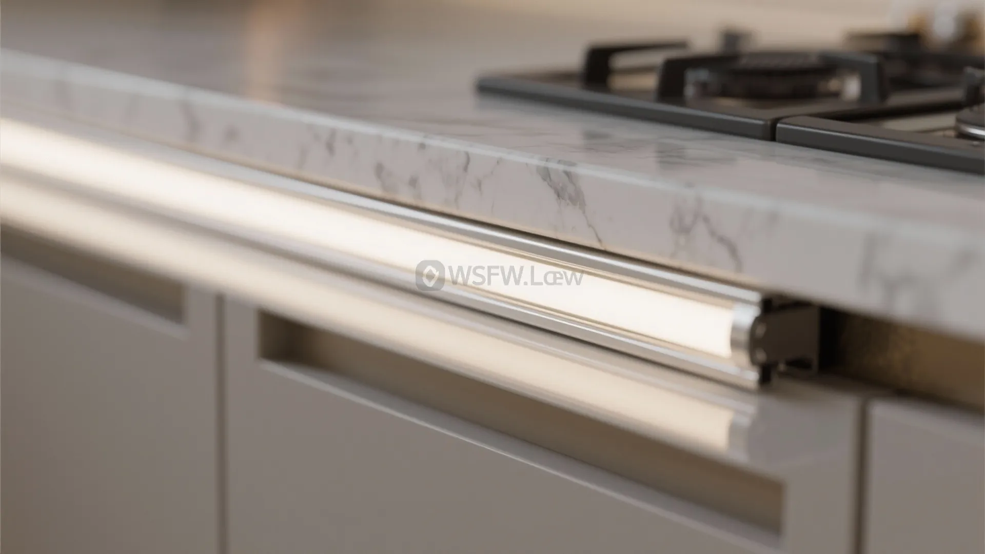 Modern kitchen with white marble countertop and a long bright LED light strip under cabinets