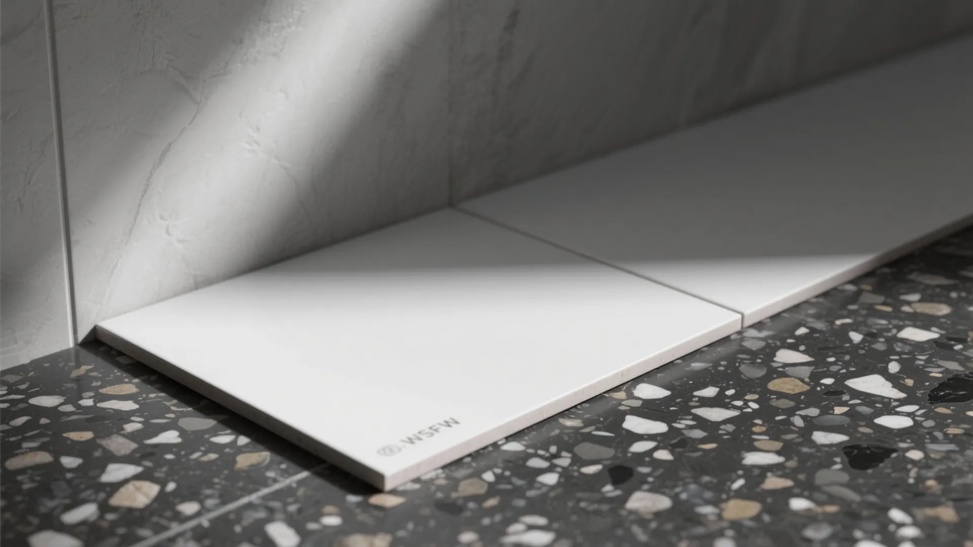 Large-format white walls with black terrazzo floor