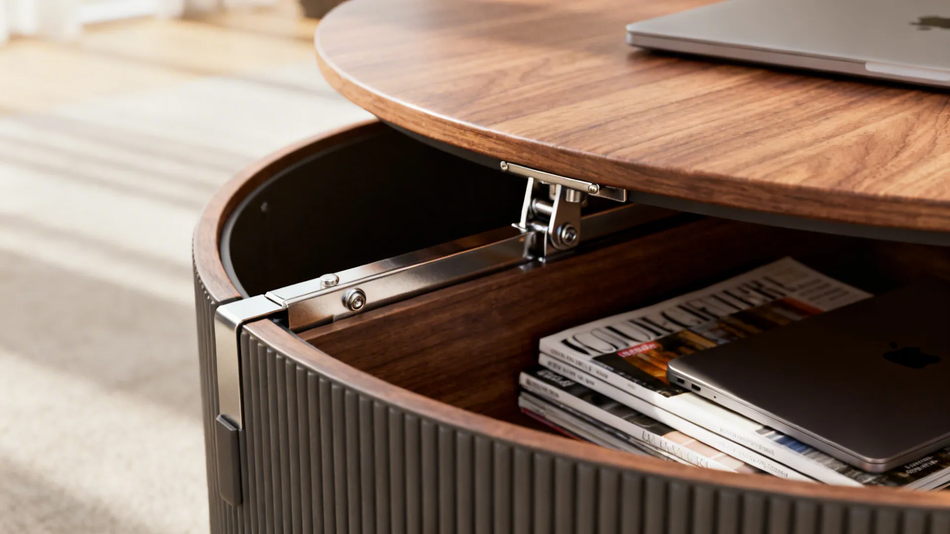 Close-up of a lift-top round coffee table showing the hinge and storage compartment with a laptop.