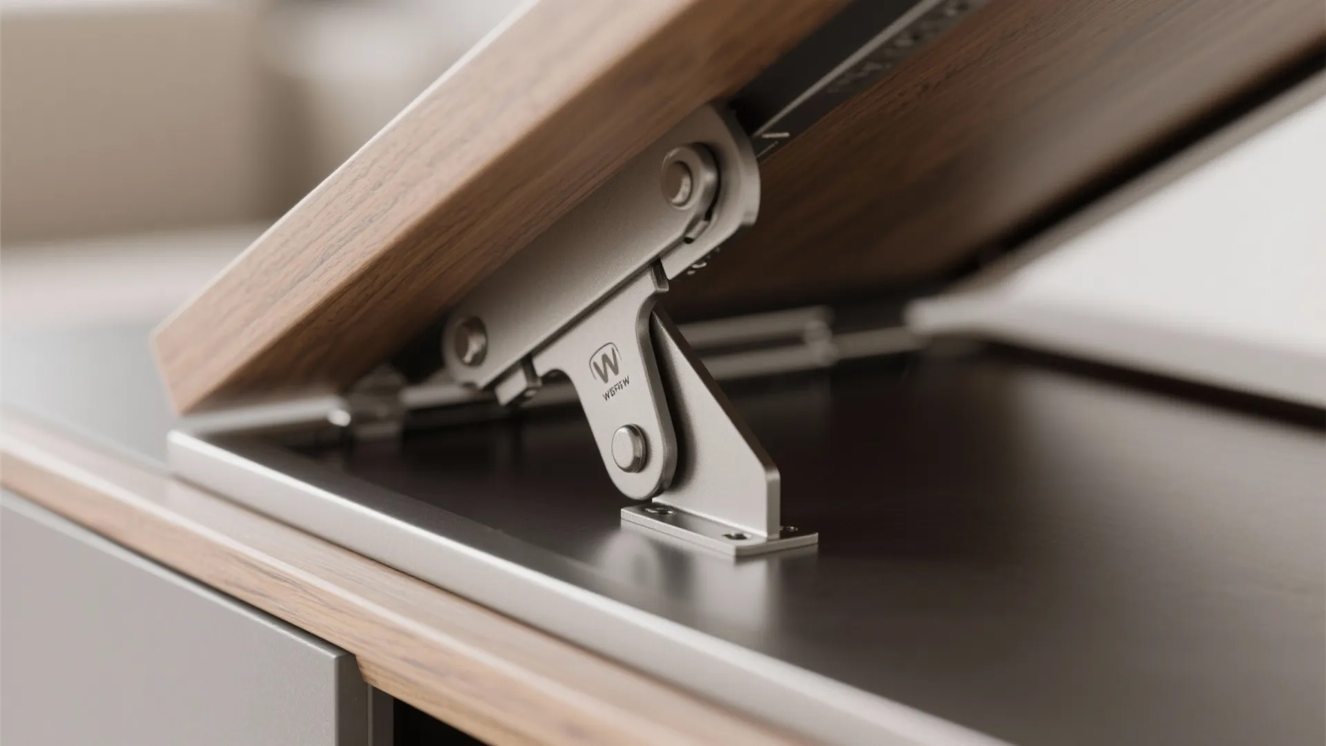 Close-up of a metal lift top hinge mechanism installed on a wooden cabinet and desk