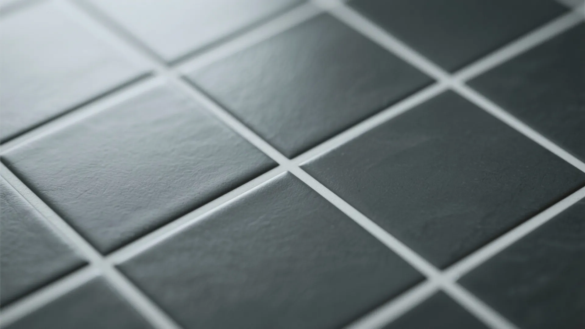 Close-up of dark grey tiles with light grout lines creating crisp contrast.