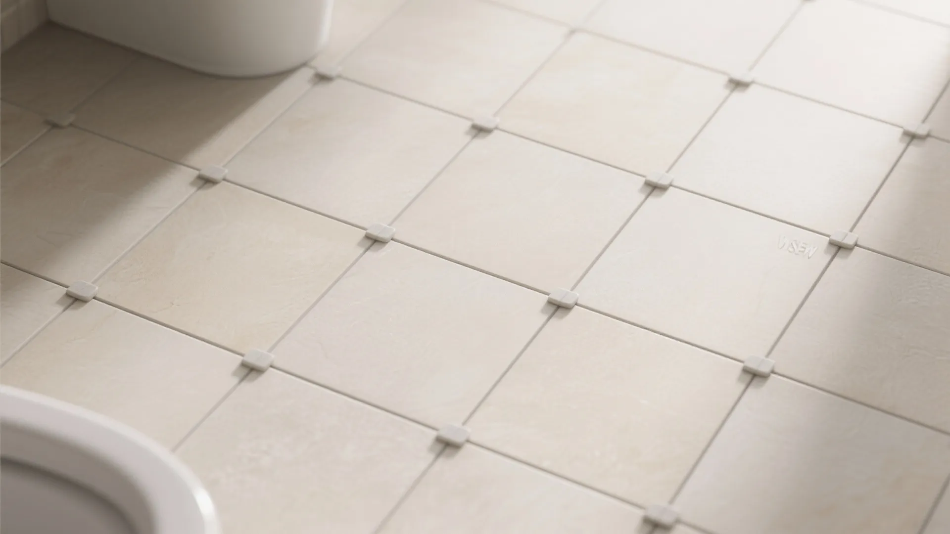 Flat lay of large light-colored bathroom tiles with minimal grout