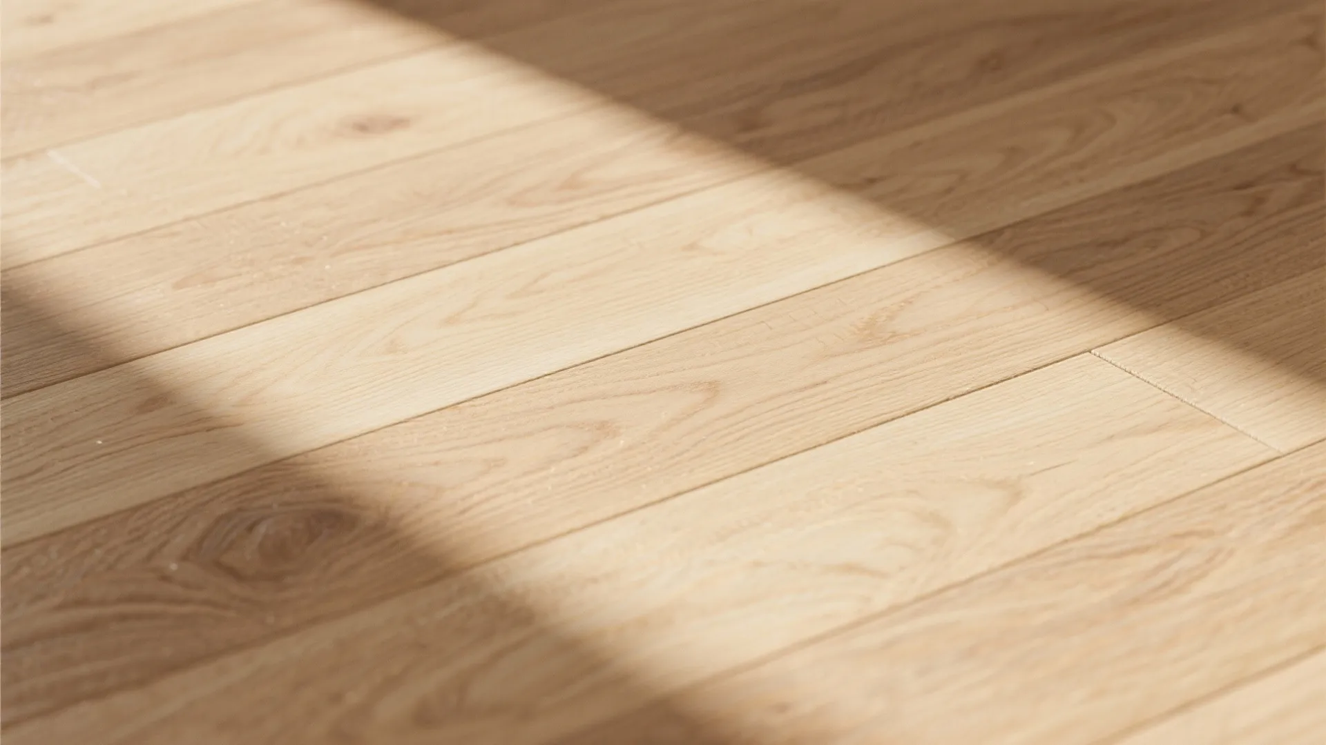 Natural light oak wood floor boards with sunlight and shadow in a bright modern home