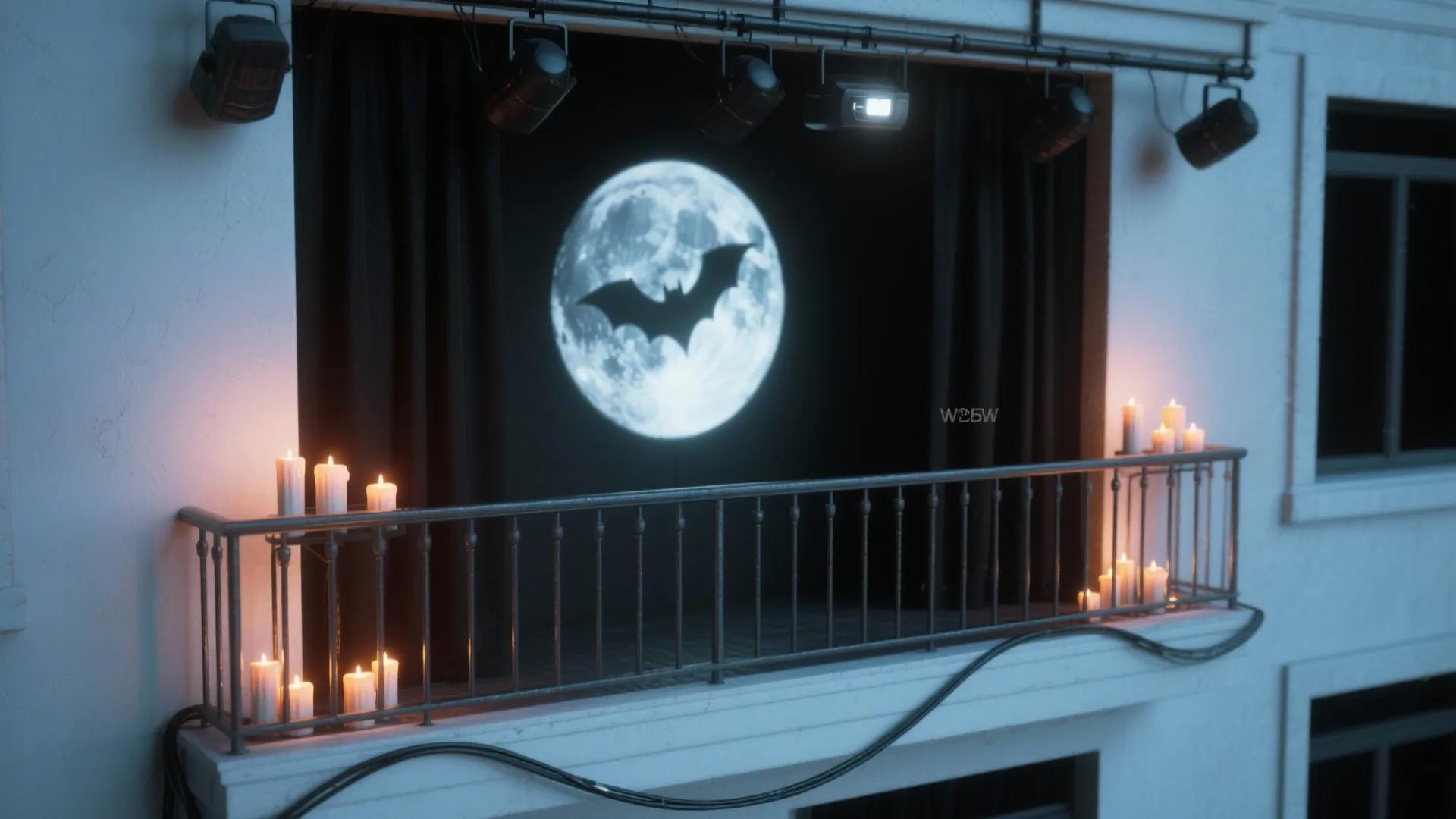 Balcony stage with black curtains featuring a full moon projection and bat silhouette with candles