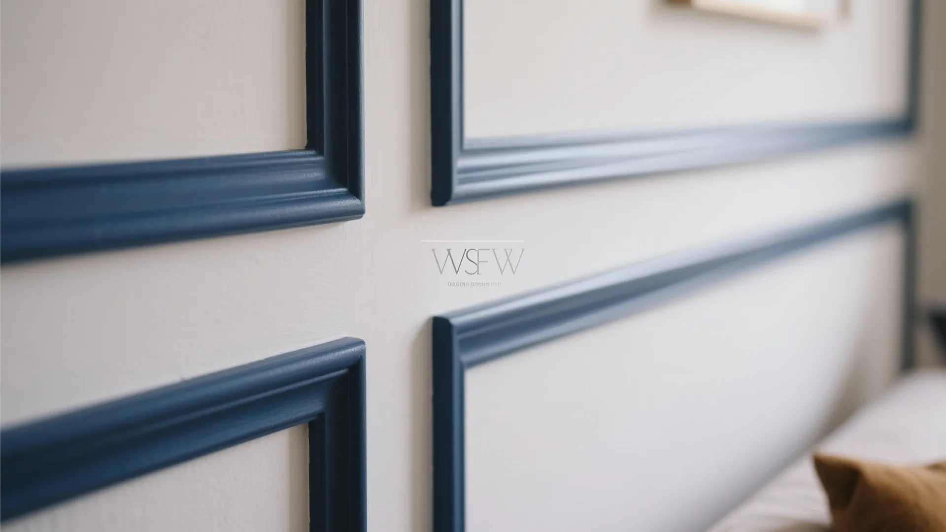 Close up view of white wall panel design with dark blue decorative frames and trim