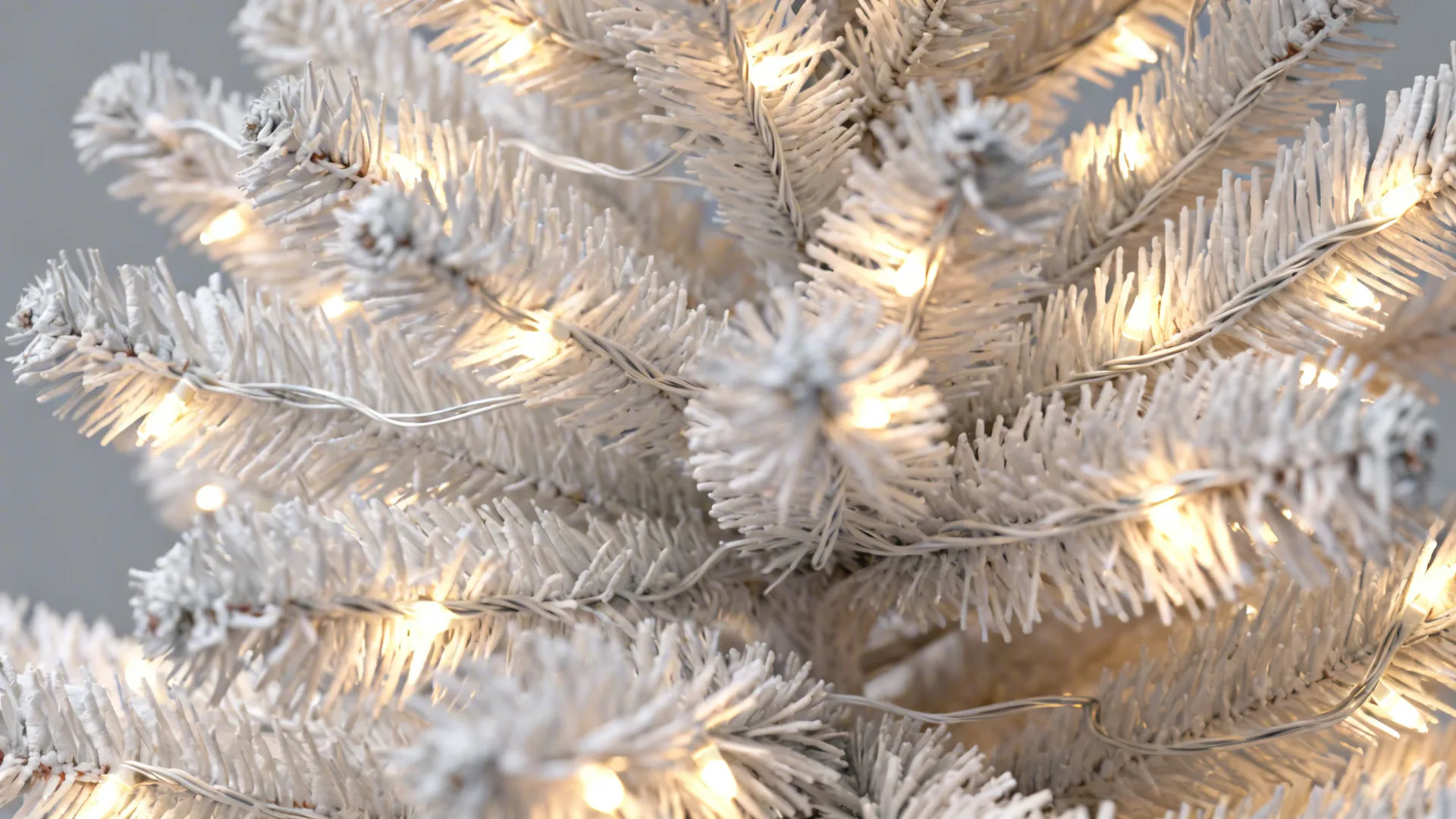 Close-up of LED lights wrapped into the inner branches of a white tree for three-dimensional glow.