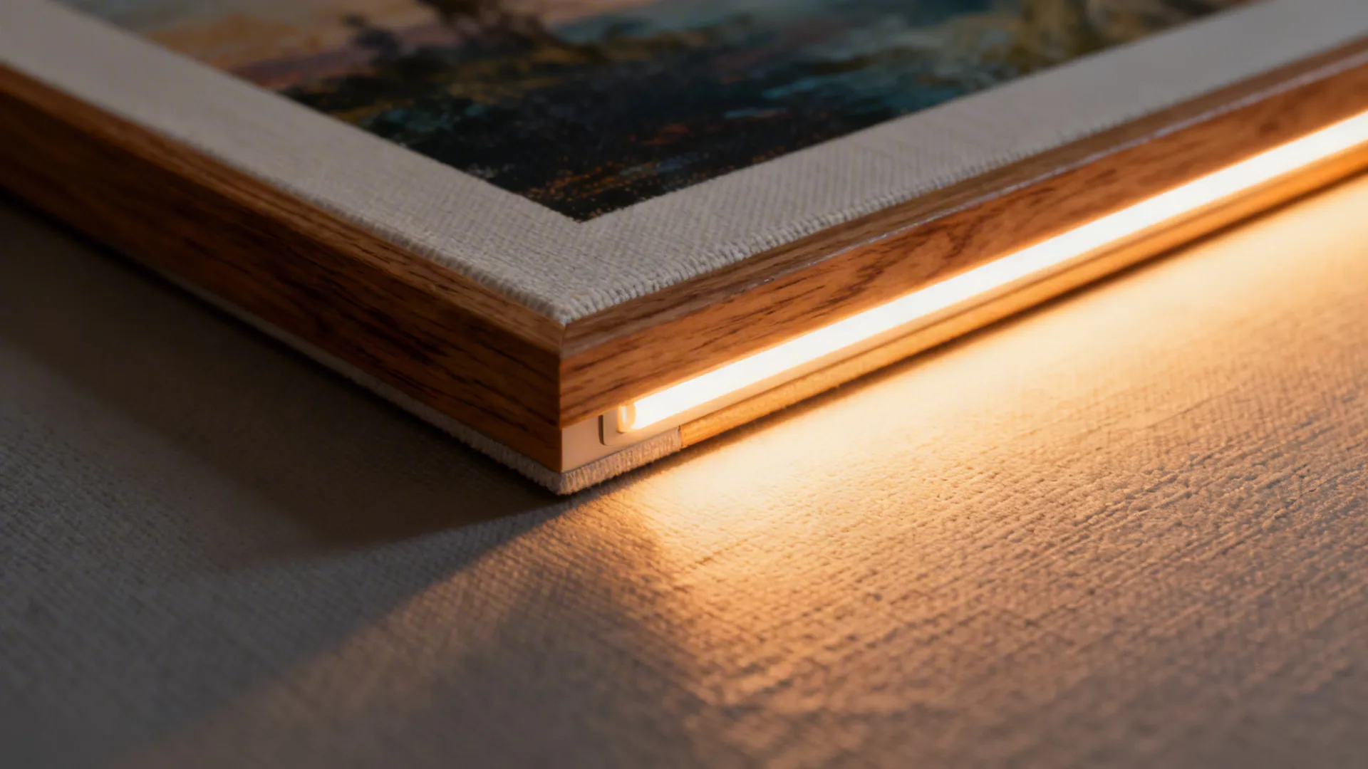 Directional picture light illuminating a framed print, showing frame edge and canvas texture