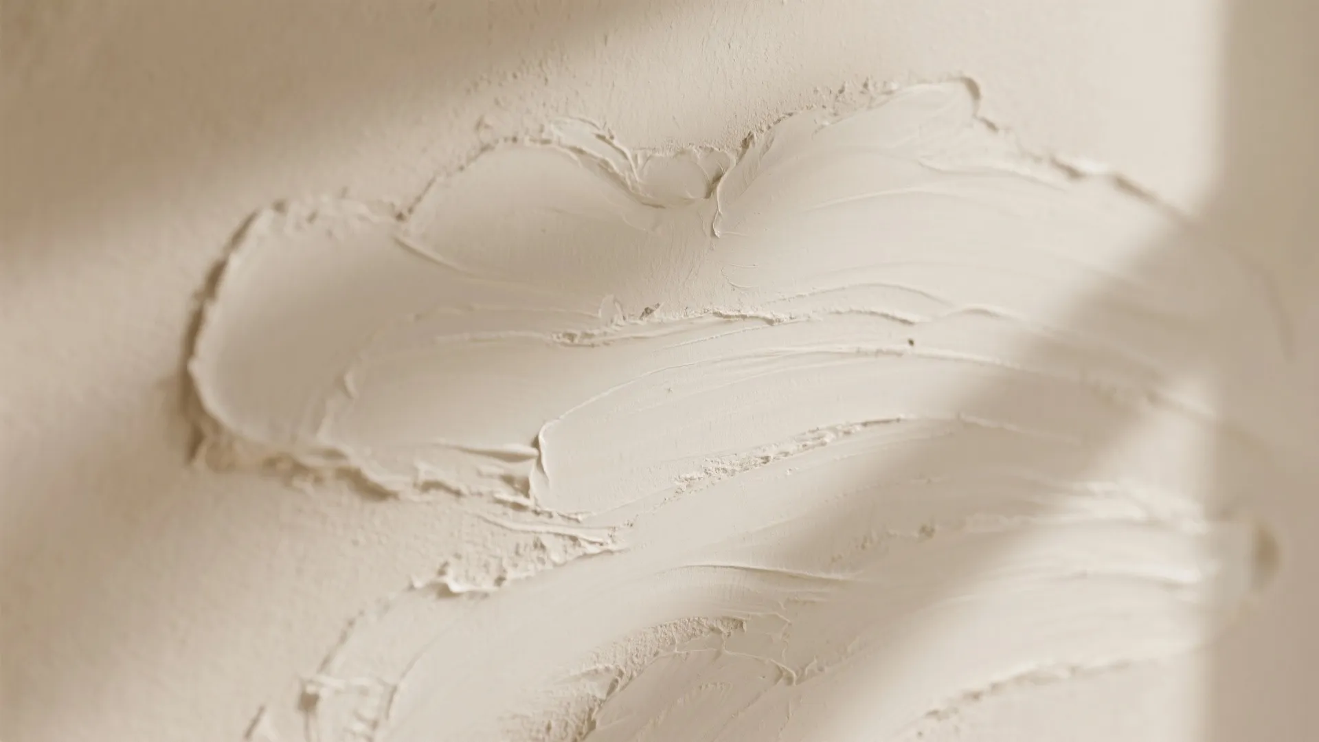 Macro view of thick beige paint texture with visible brush strokes on a flat surface