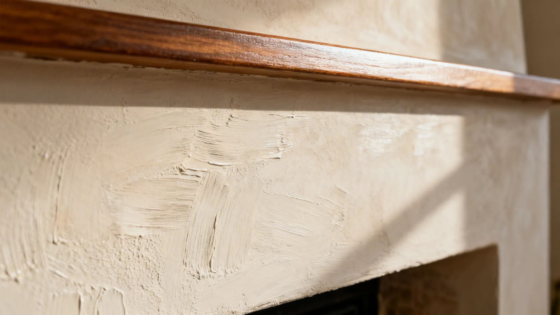 Close-up of limewash texture on a chimney breast with light grazing across the surface.