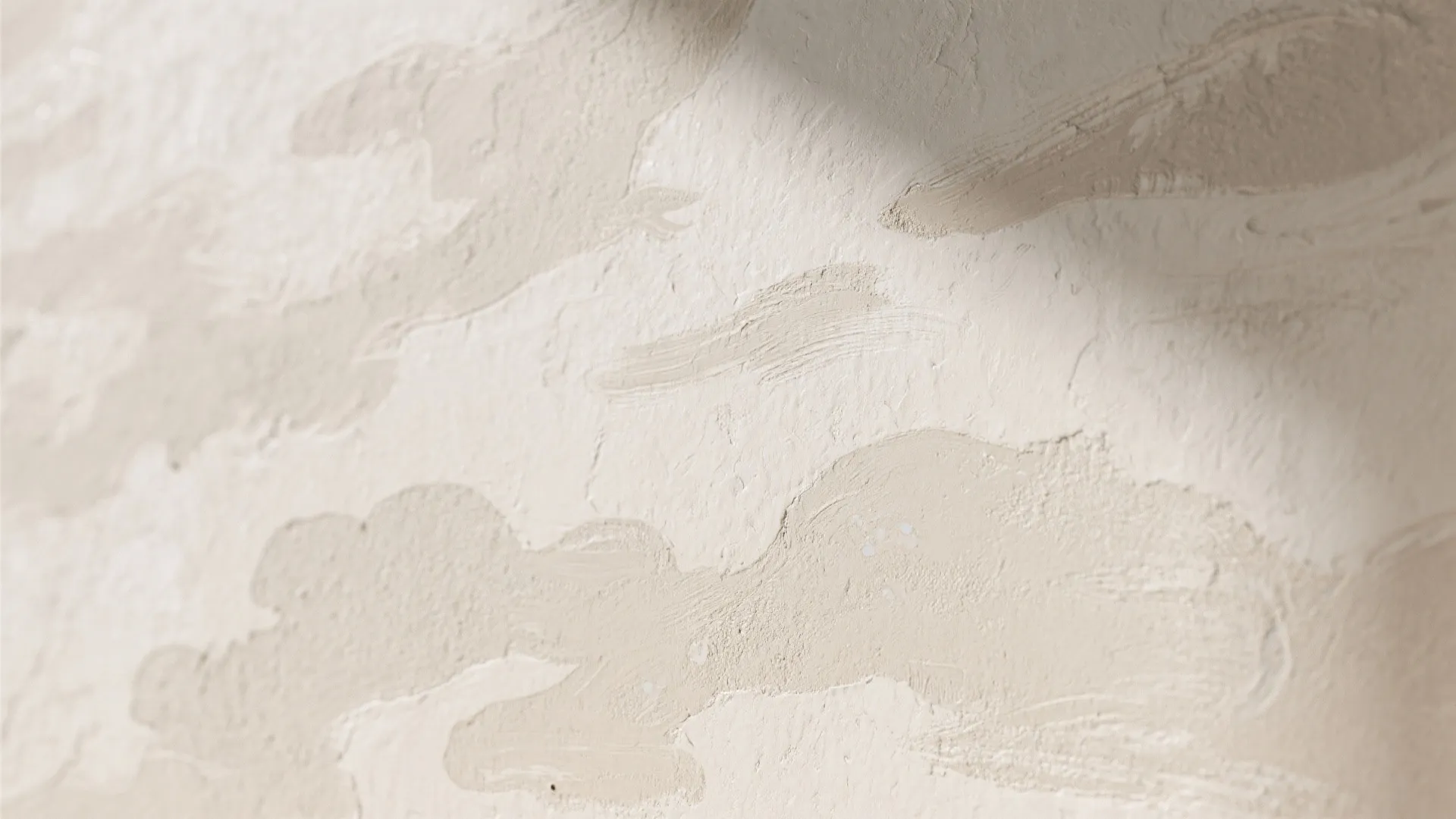 Close up of textured cream wall paint with natural sunlight and soft shadows indoors scene