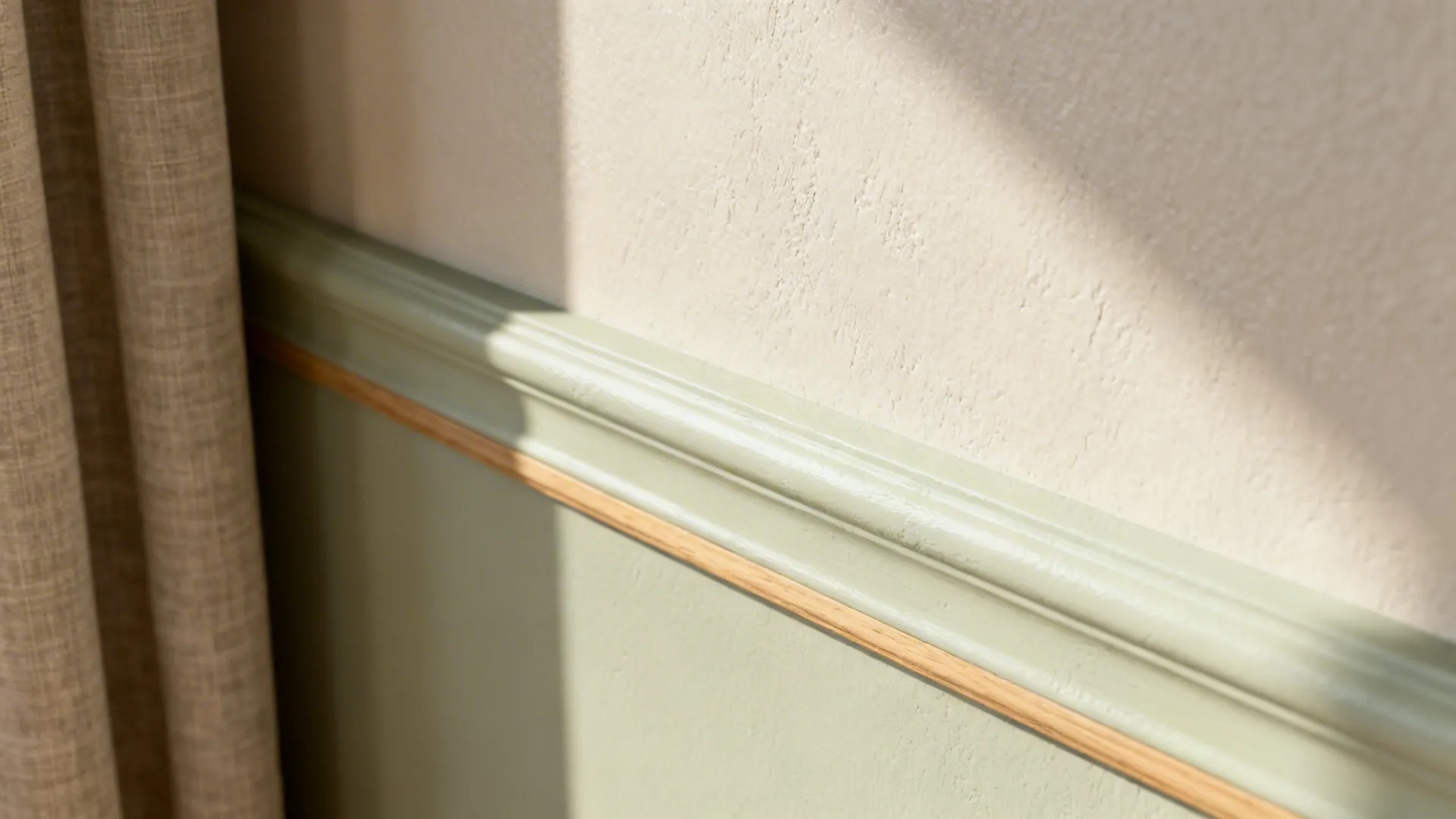 Macro of limewash accent meeting eggshell wall with soft texture in warm light.