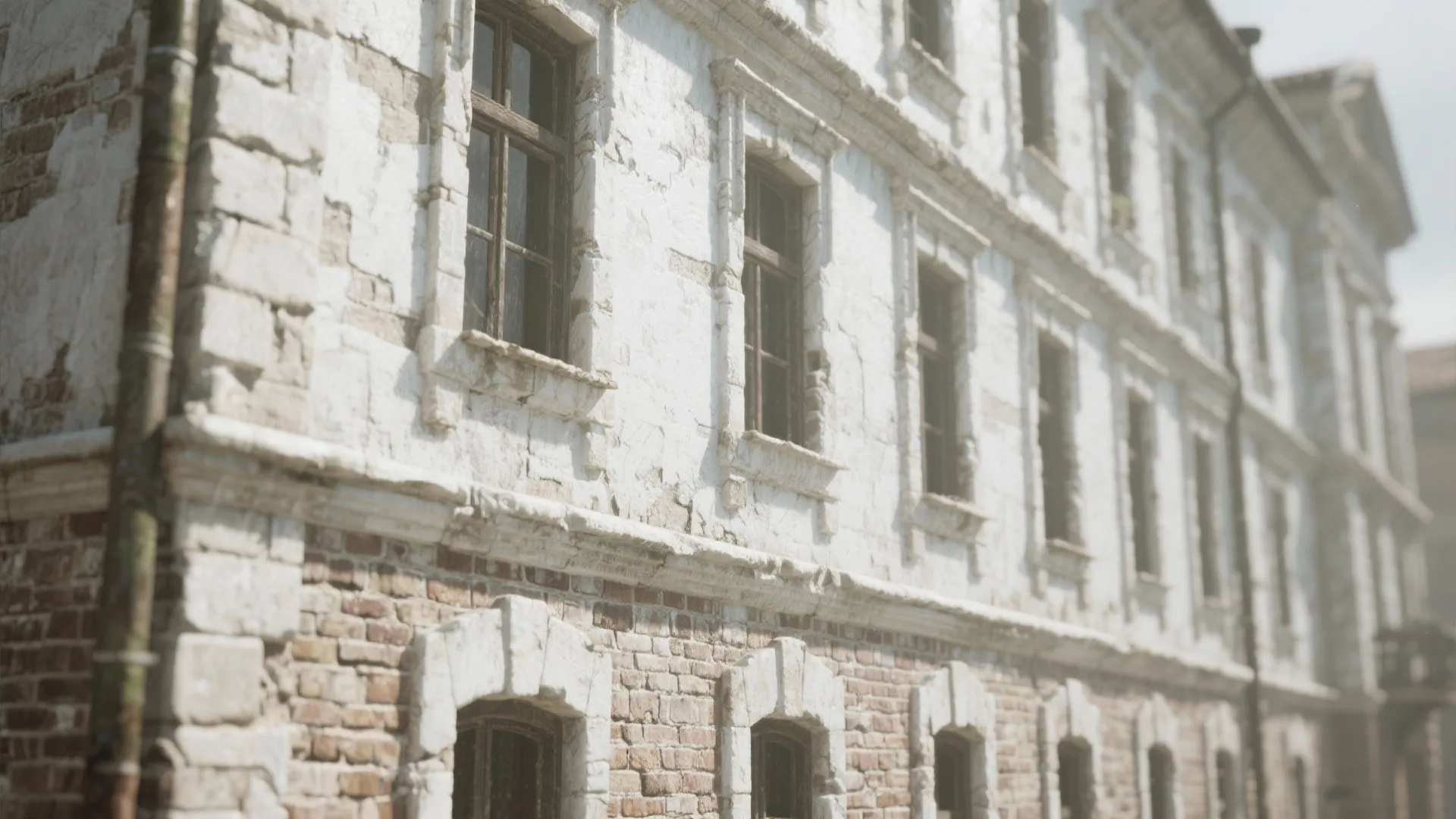Old building with white paint showing brown bricks underneath and many dark frame glass windows