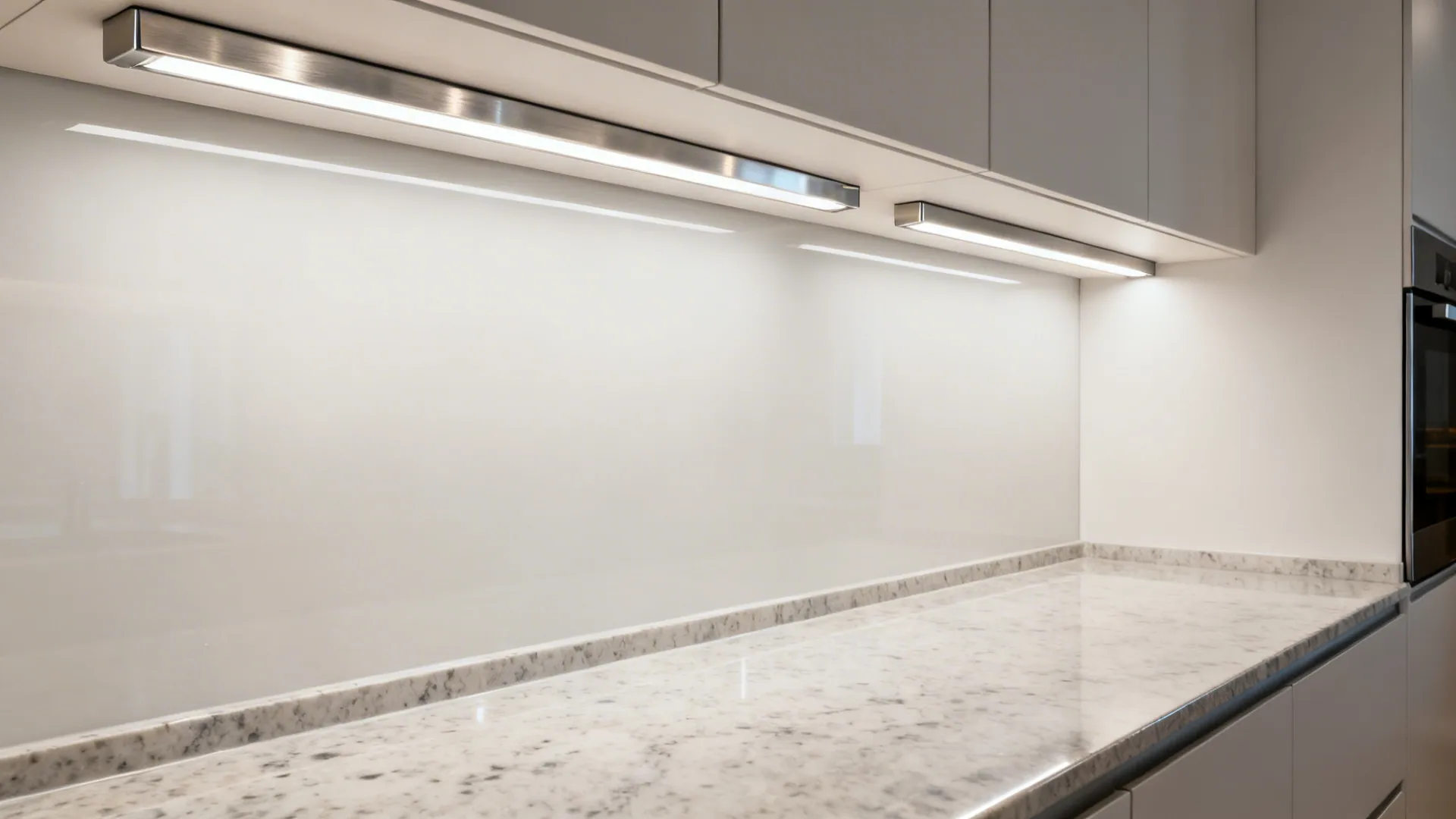 Slim linear under cabinet bars provide uniform, low-glare lighting on polished quartz.