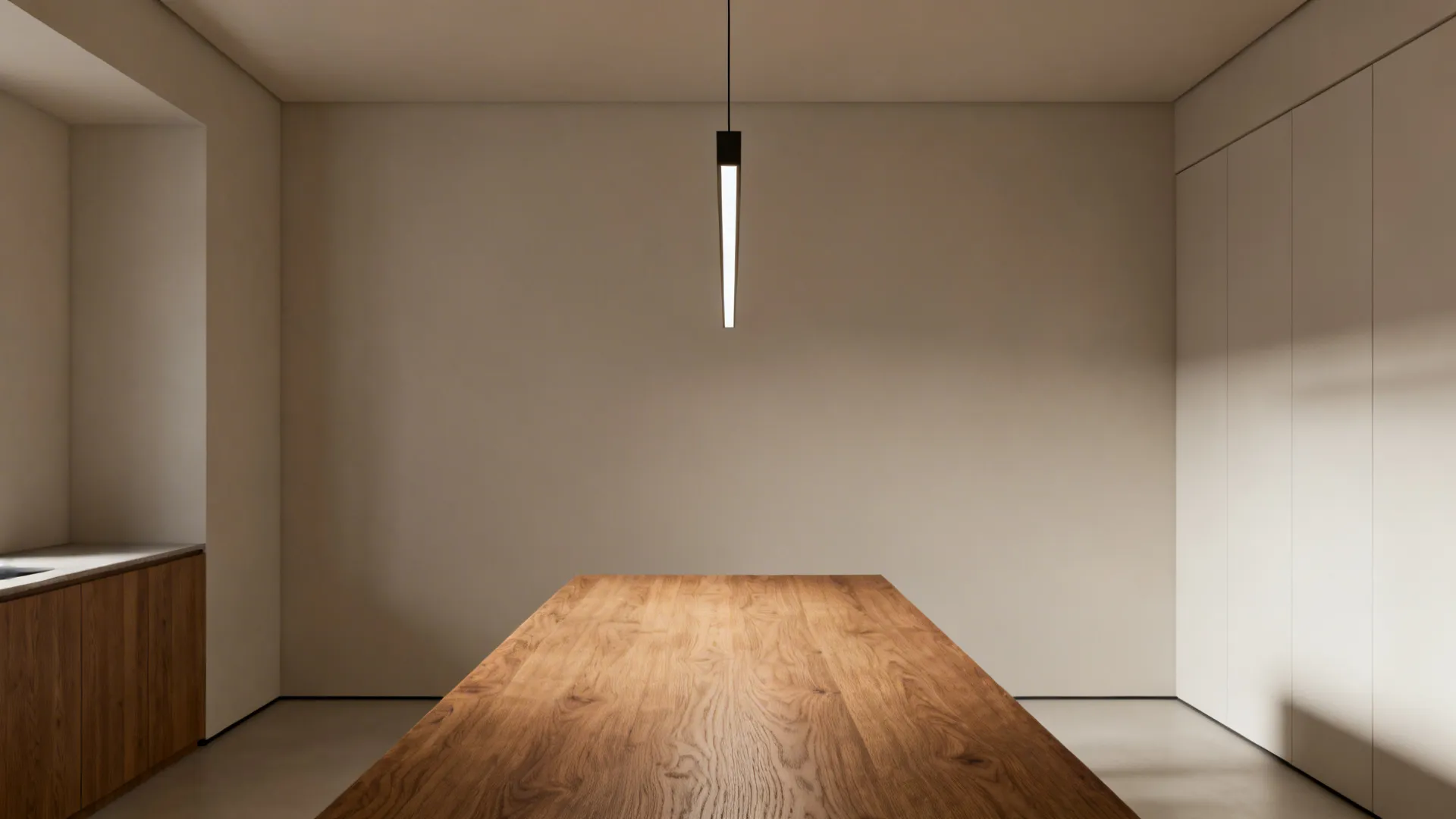 Long narrow dining table illuminated by a slim linear pendant, showing clean sightlines and even task lighting