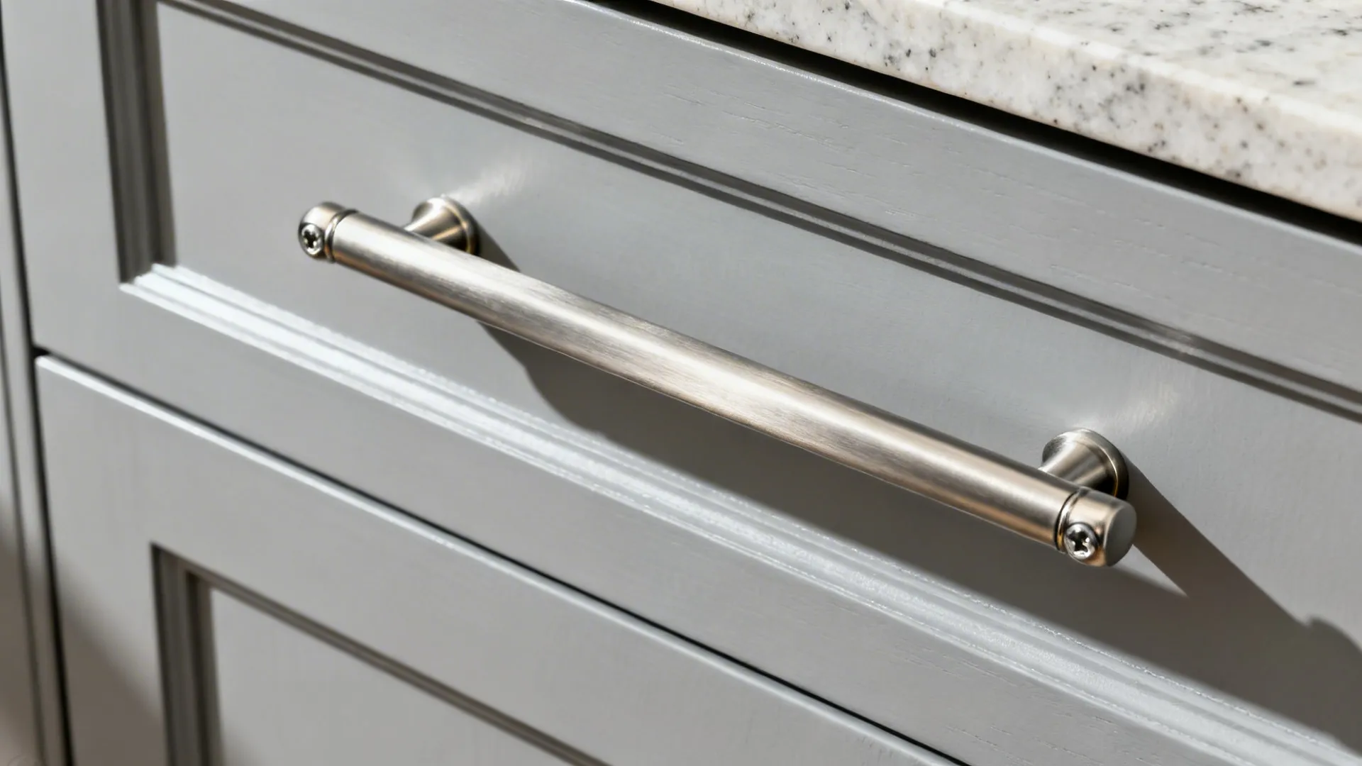 Close-up of a brushed nickel linear pull on a light gray Shaker drawer.