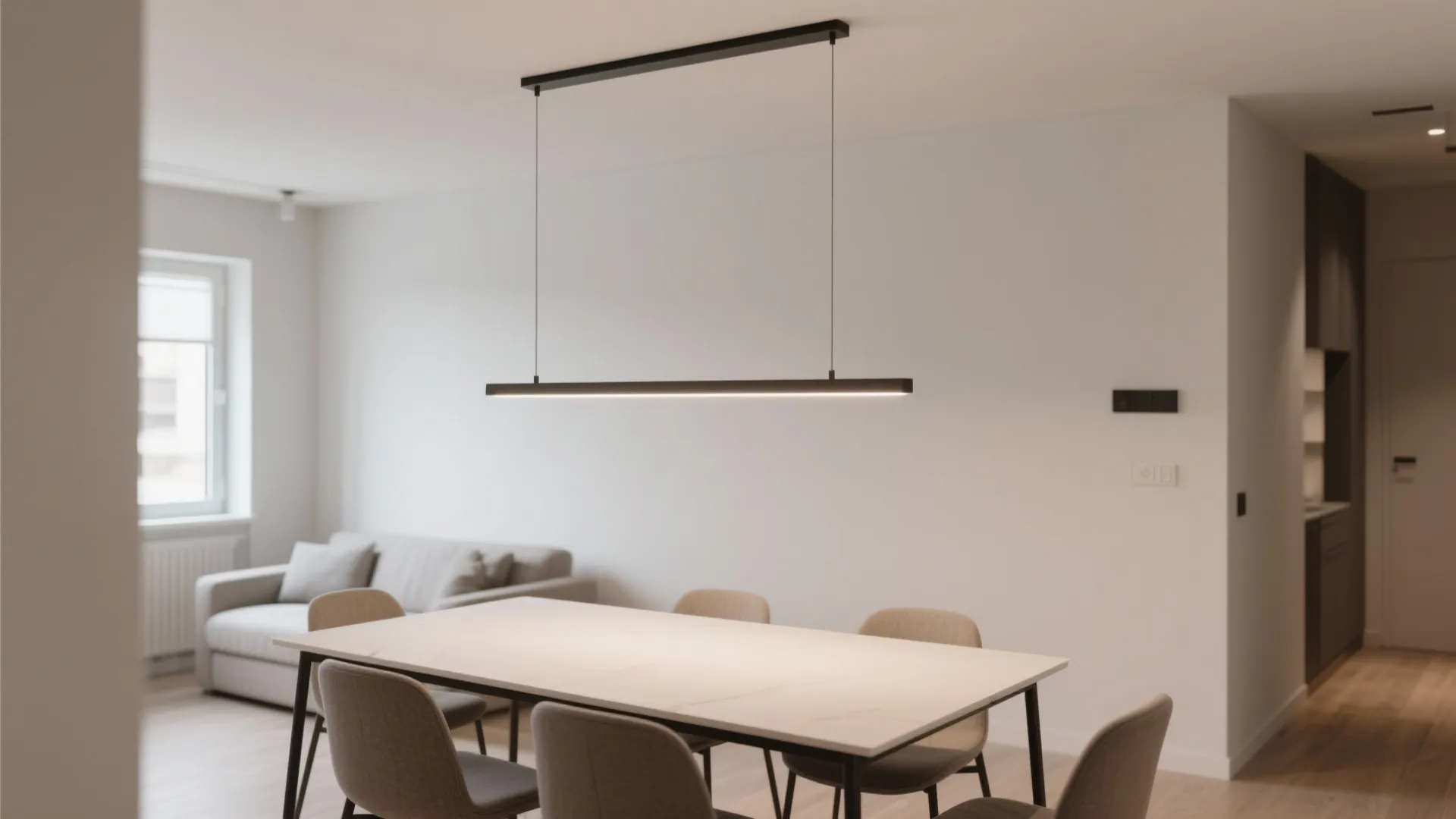 Rectangular dining table with a slim linear suspension light