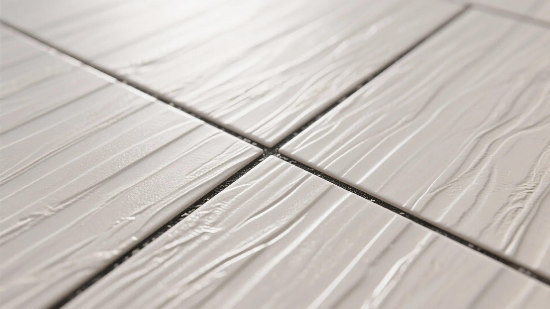 Macro of linear-textured porcelain floor tile with shallow grooves and dark grout.