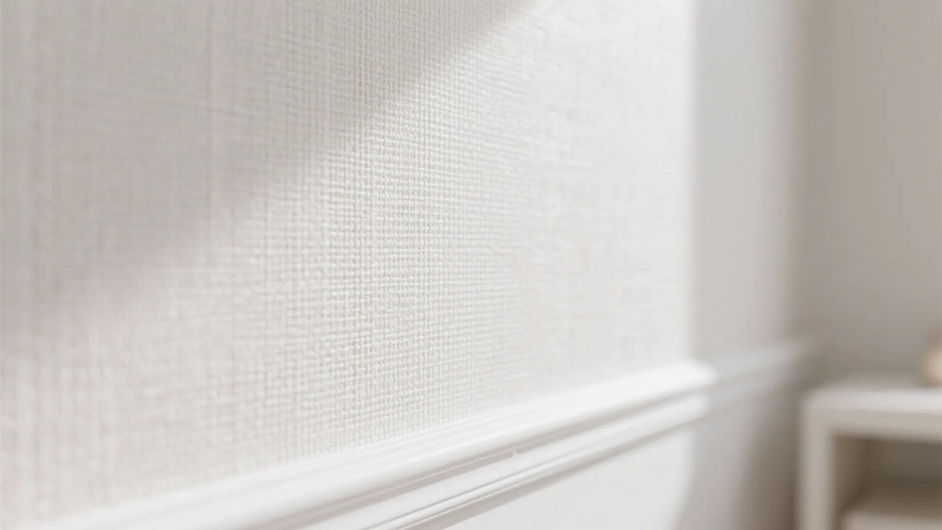 Close up view of white fabric wall panel with soft natural sunlight and white baseboard