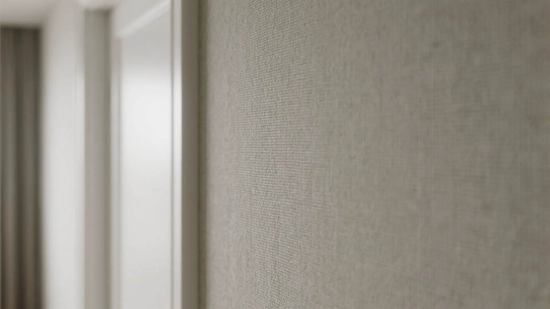 Close up view of grey fabric texture wallpaper on a wall next to white door frame