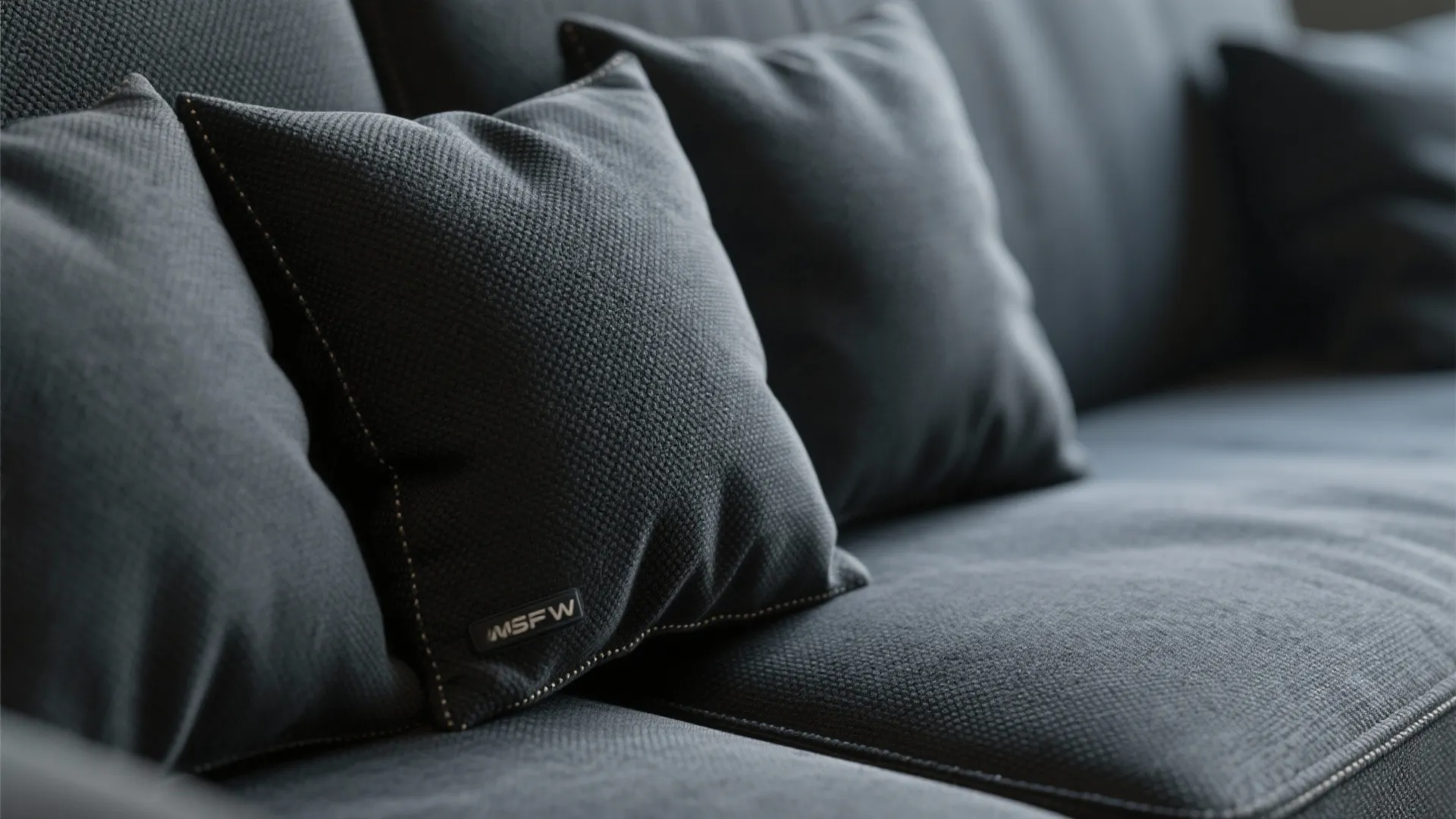 Macro view of dark performance fabric with fine weave and stitching on theater cushions.
