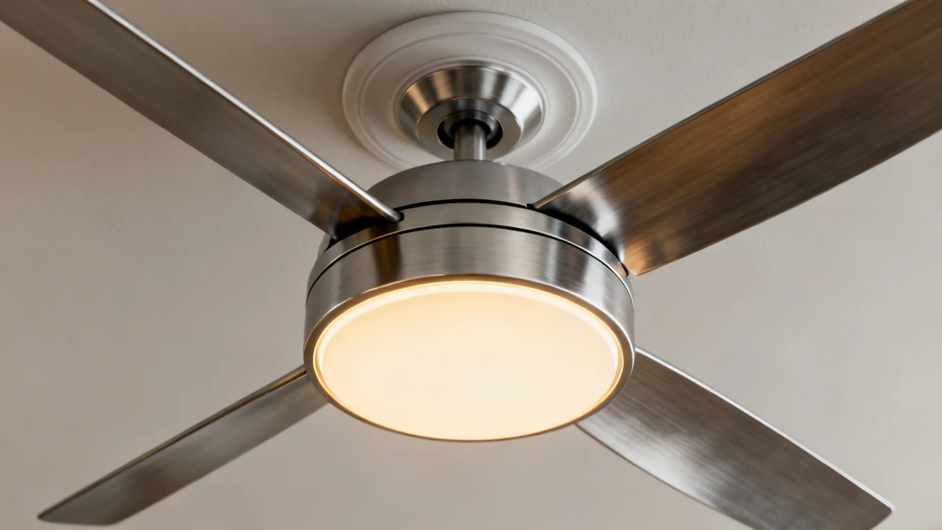 Close-up of a low-profile flush-mount ceiling fan with integrated LED and brushed metal finish