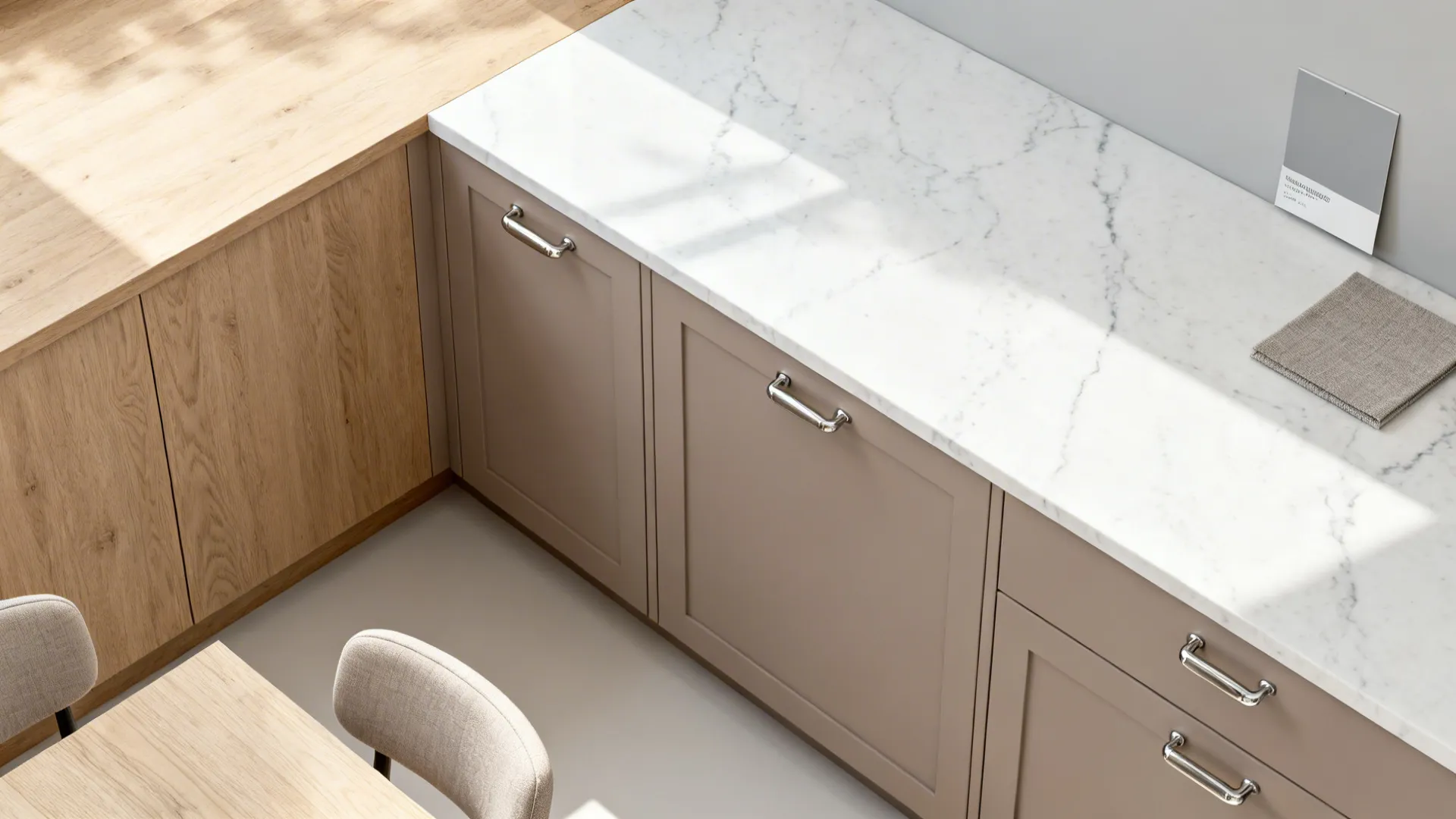 Flat lay of light oak, matte taupe fronts, white quartz, nickel hardware, and soft gray fabric.